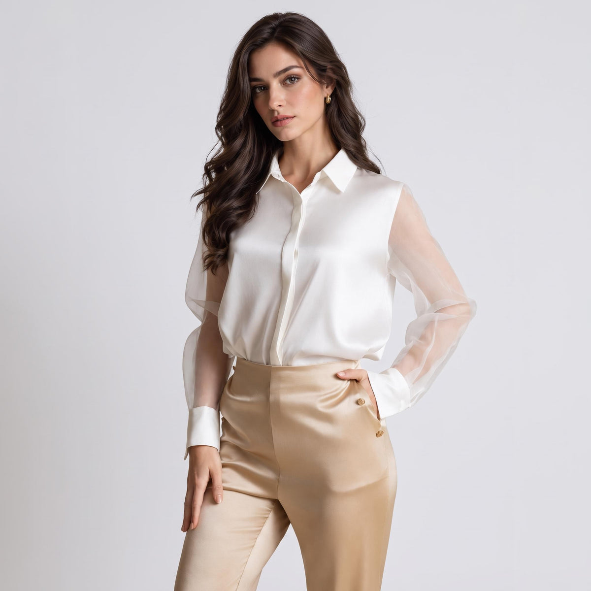 Elegant white silk blouse with sheer long sleeves, a classic lapel collar, and button-up front worn with gold trousers.