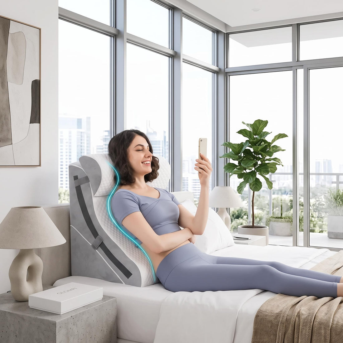Woman sitting in bed using a grey, 3-piece adjustable memory foam wedge pillow set for ergonomic back and neck support.
