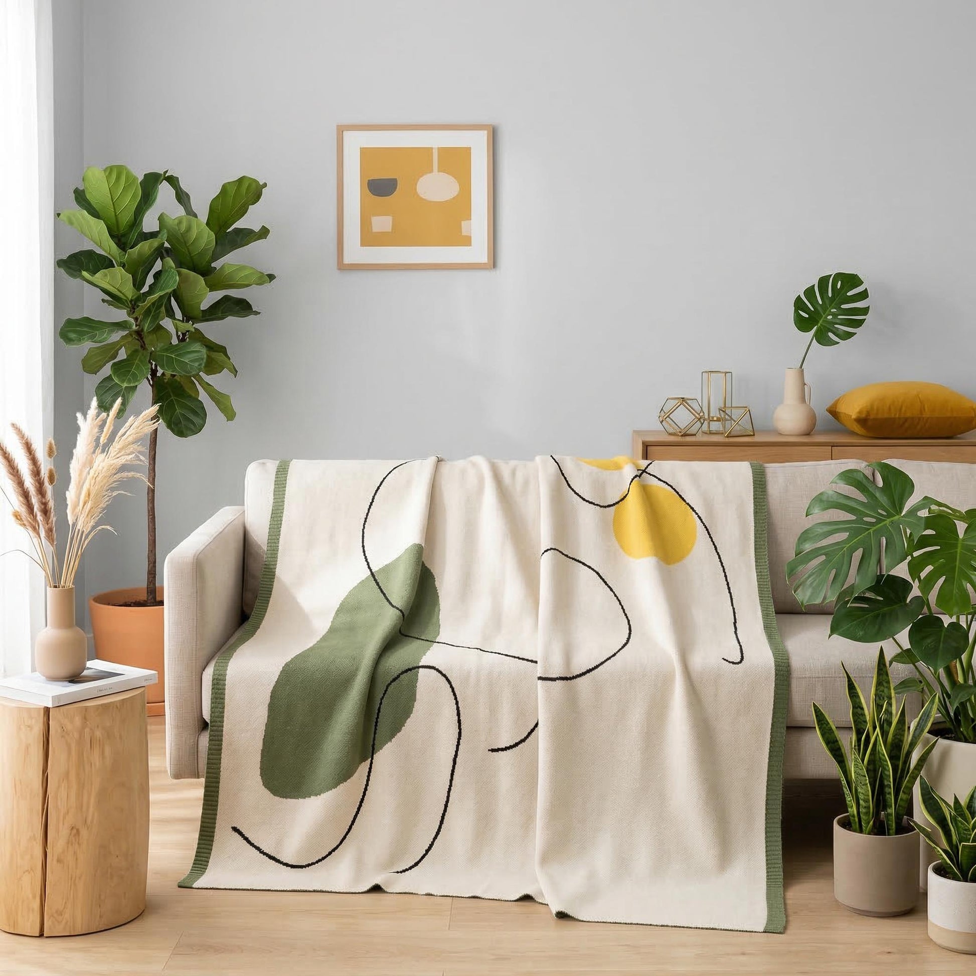 Abstract knitted throw blanket in earthy tones with organic shapes draped over a modern sofa.