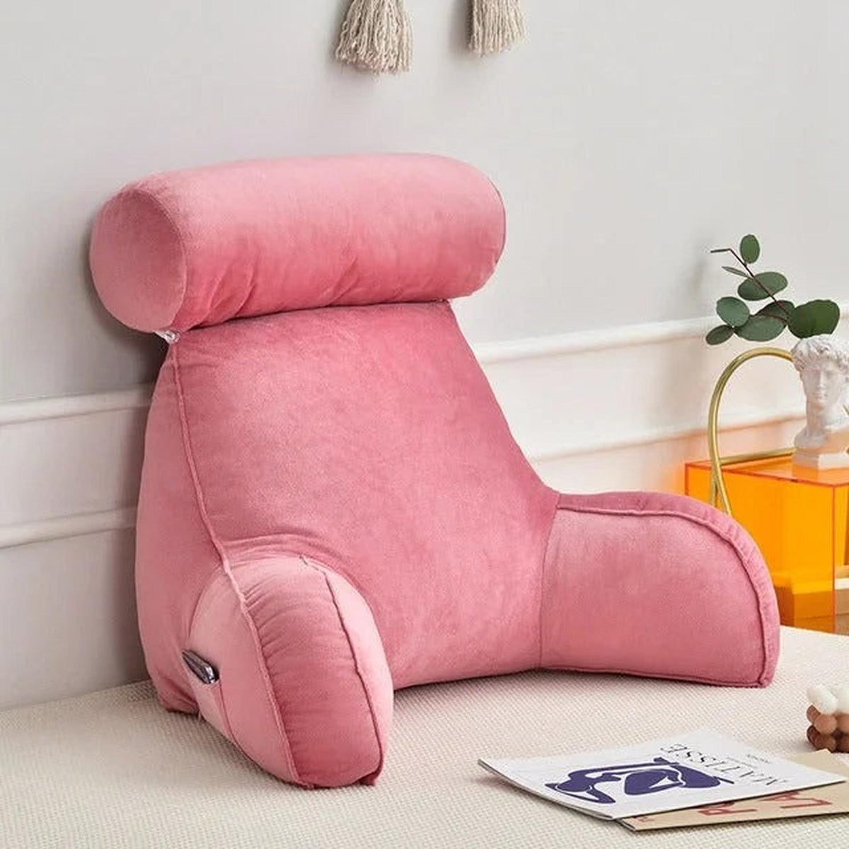 Pink velour adjustable backrest pillow with arms, headrest, and side pocket for bed or sofa.