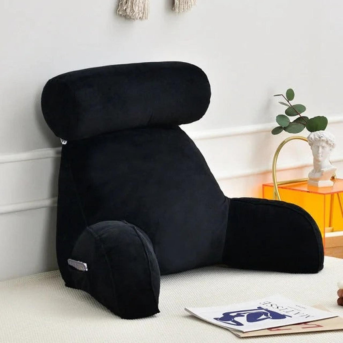 Black velour adjustable backrest pillow with arms, headrest, and side pocket for bed or sofa.