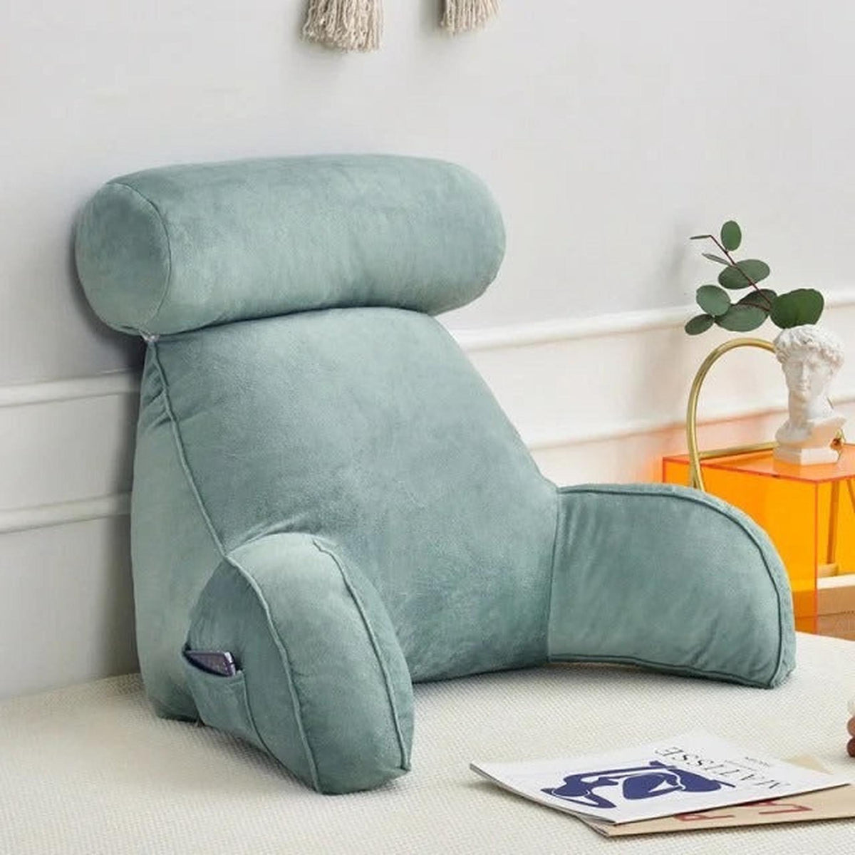 Adjustable velour backrest pillow with arms in a soft sage green, featuring a side pocket and removable headrest.