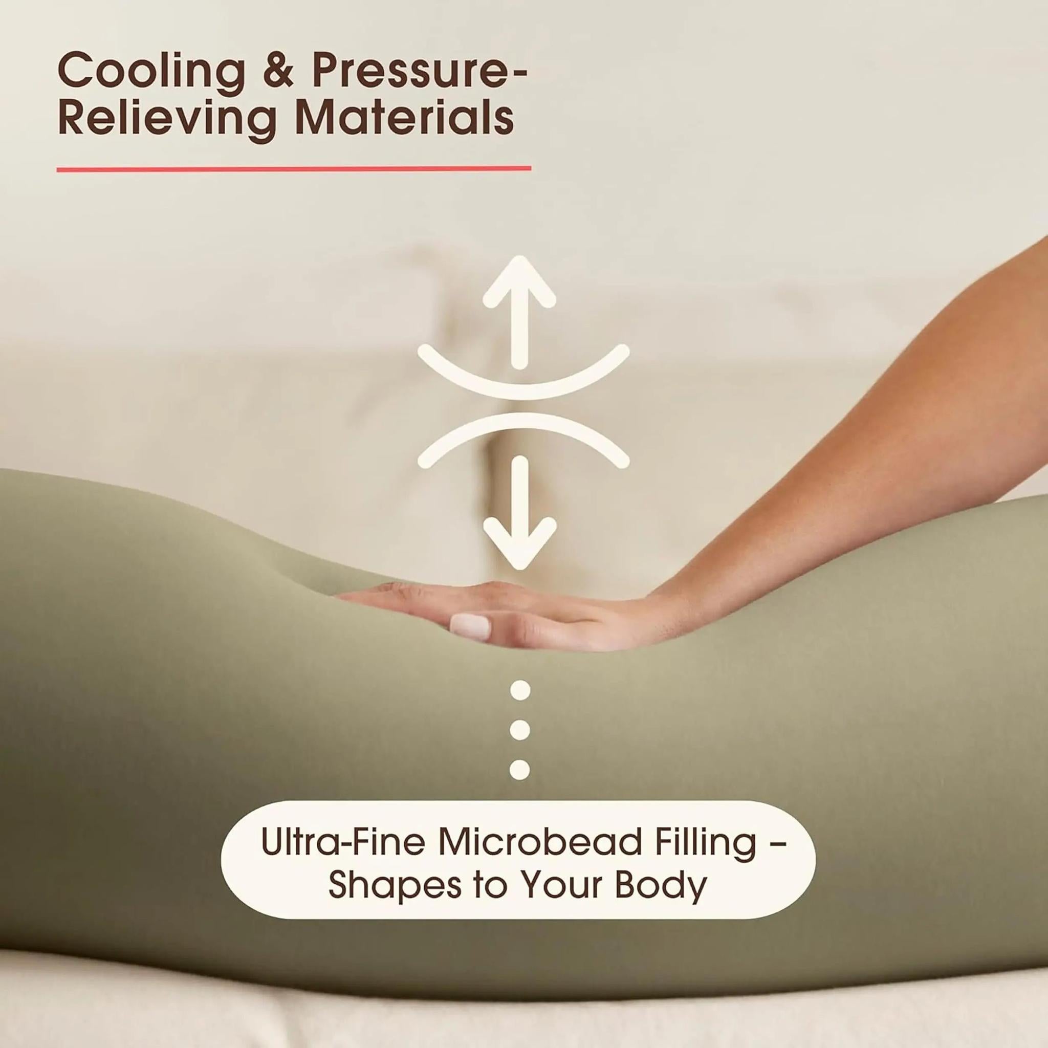 Hand pressing into a light green U-shaped pregnancy pillow, highlighting its micro-bead filling.