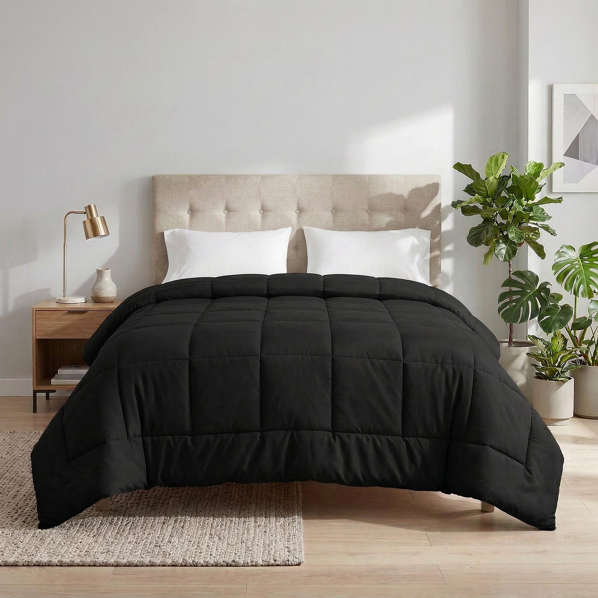 Black microfiber all-season comforter with box stitching on a bed with white pillows.