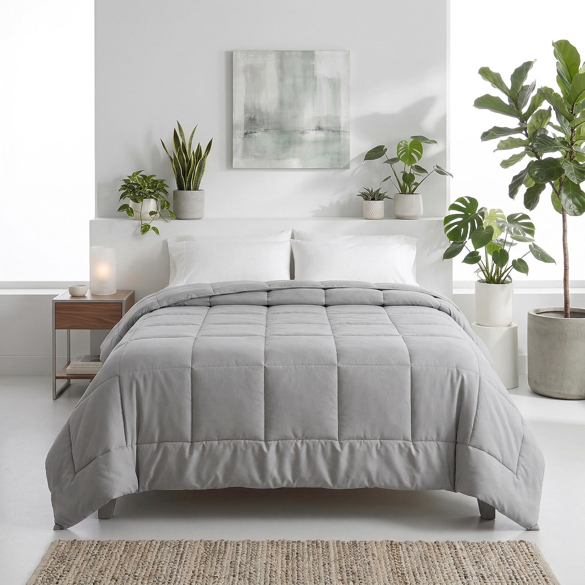 Light gray microfiber all-season comforter with box stitching on a bed.