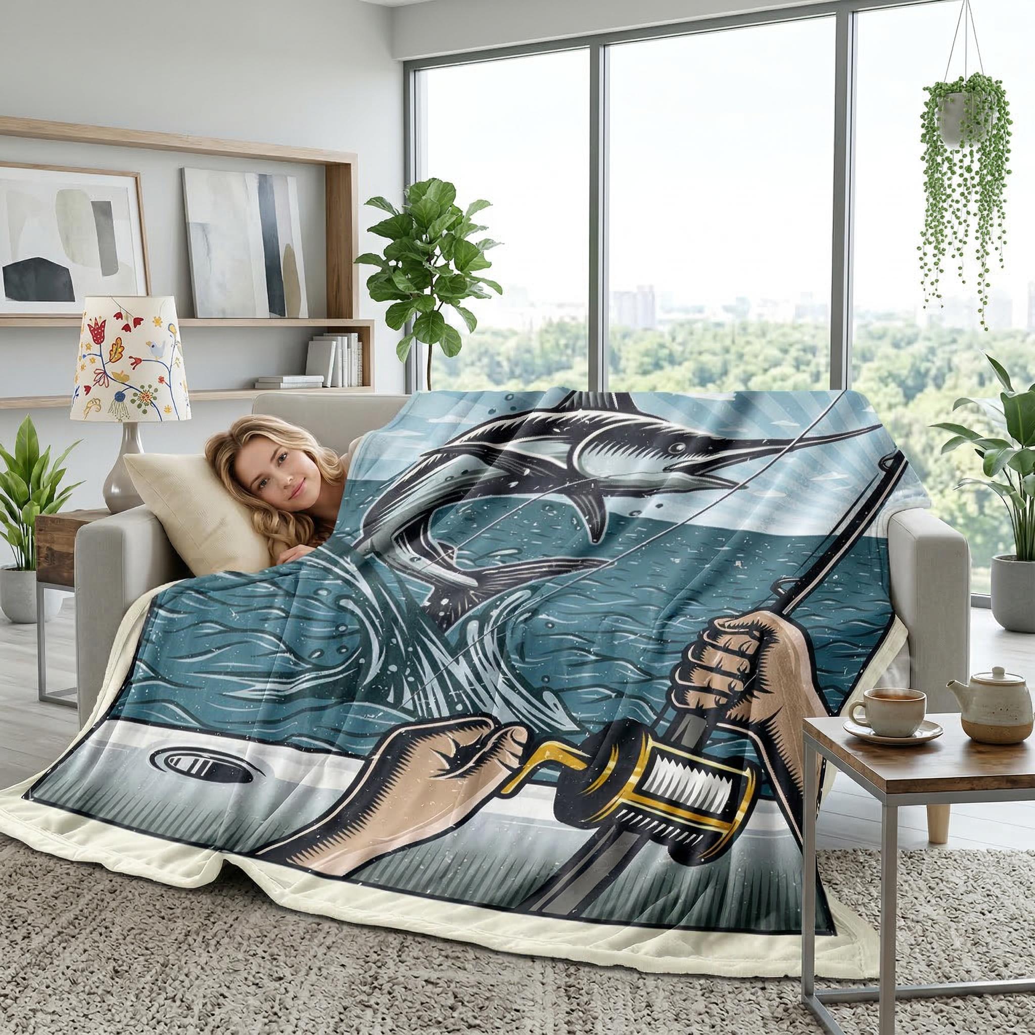 Soft flannel blanket with a blue fishing scene featuring a marlin, draped over a woman on a sofa.
