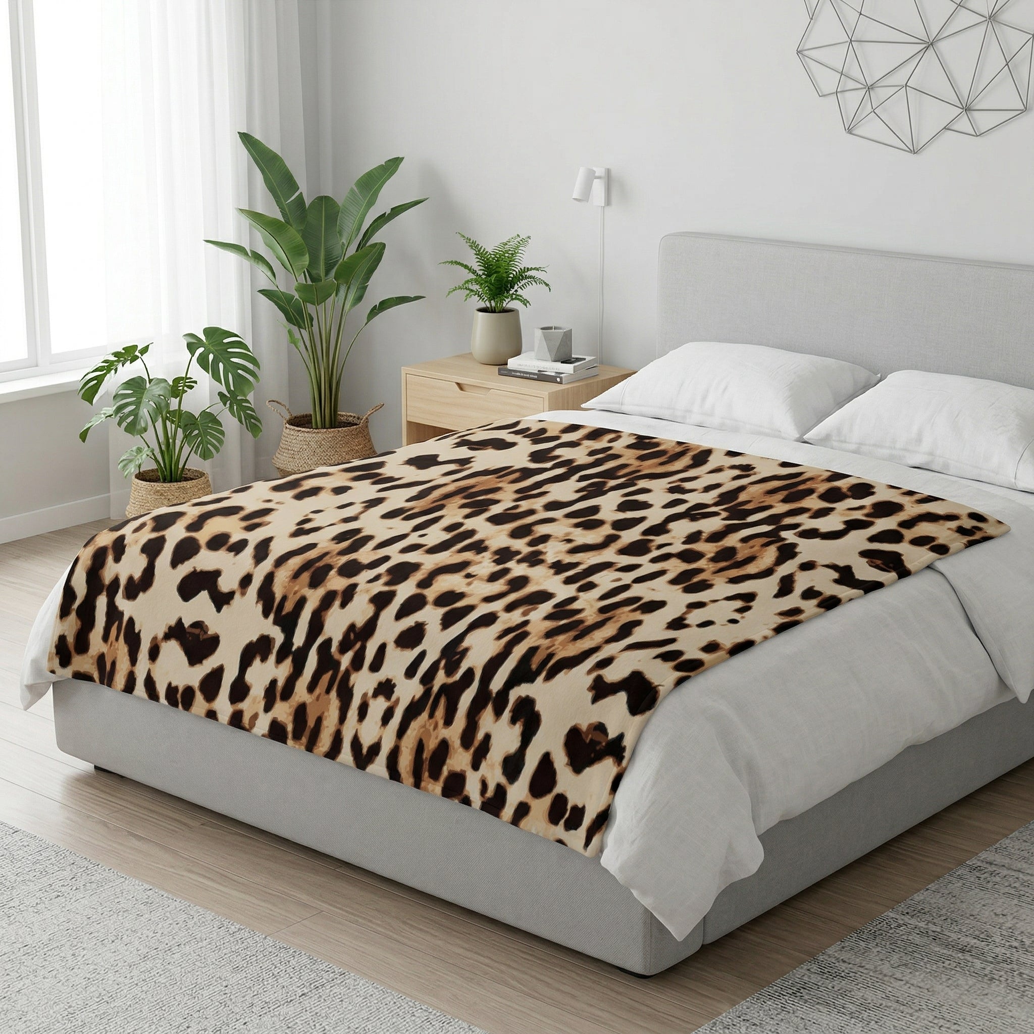 Leopard print flannel blanket draped over a modern bed in a bright room.