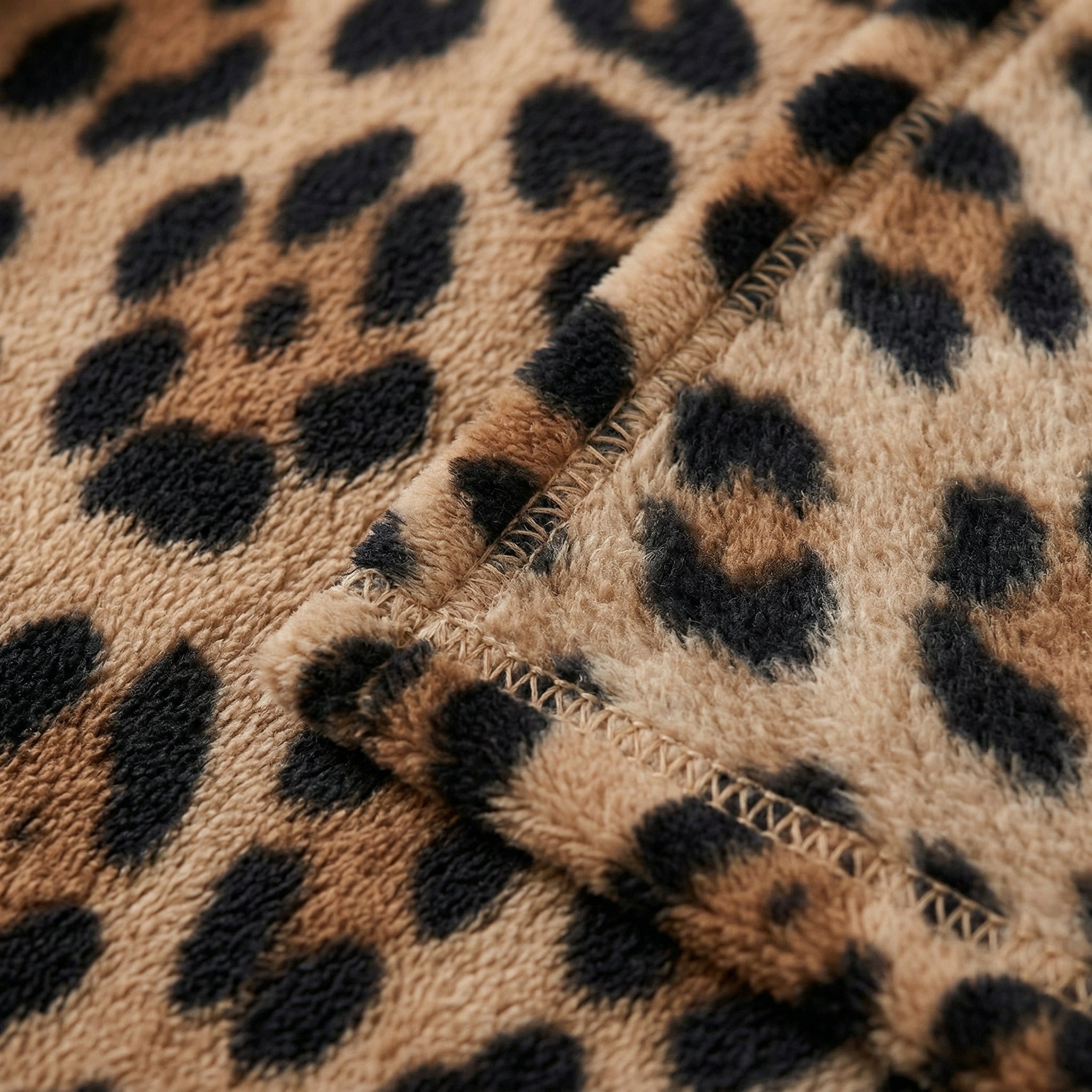 Soft flannel blanket with a brown and black leopard print pattern and visible stitching.