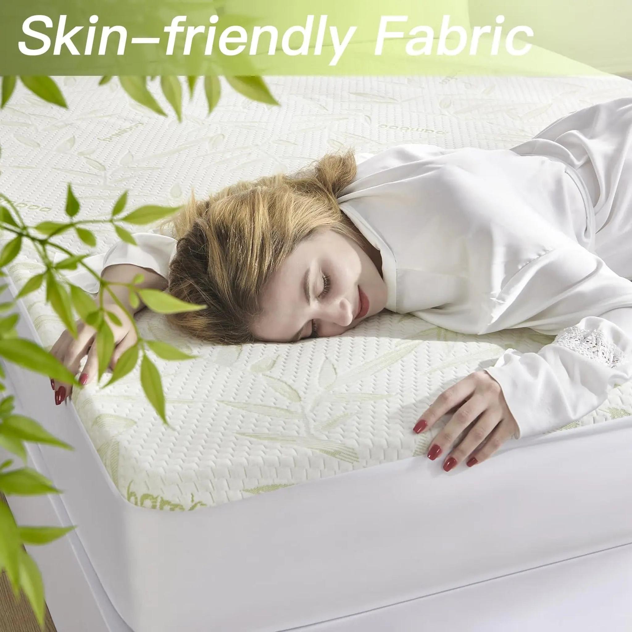 Woman sleeping comfortably on a white bamboo fiber mattress protector with a subtle leaf pattern.