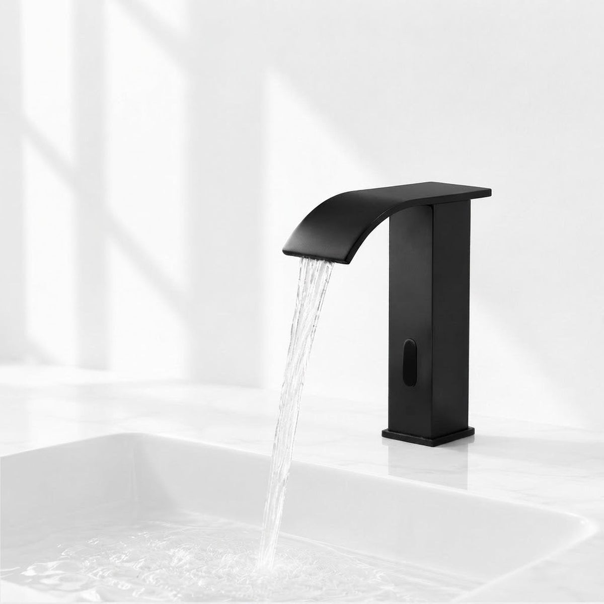 Modern matte black touchless bathroom faucet with a waterfall spout and motion sensor over a white basin.