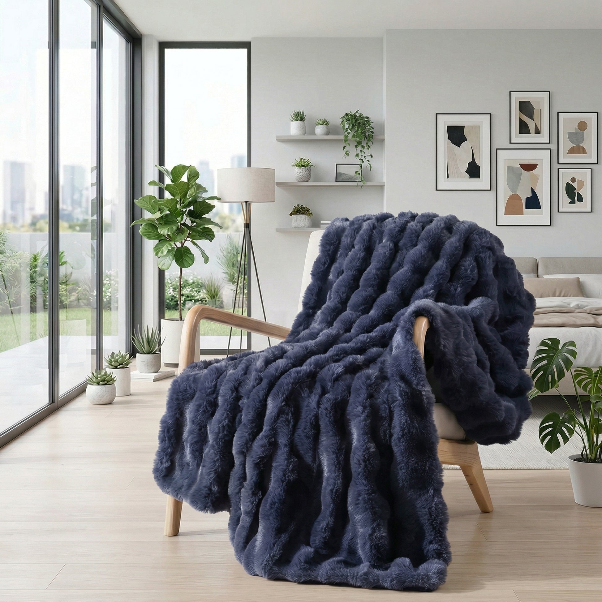 Plush navy blue faux fur throw blanket draped over a light wood armchair in a modern living room.
