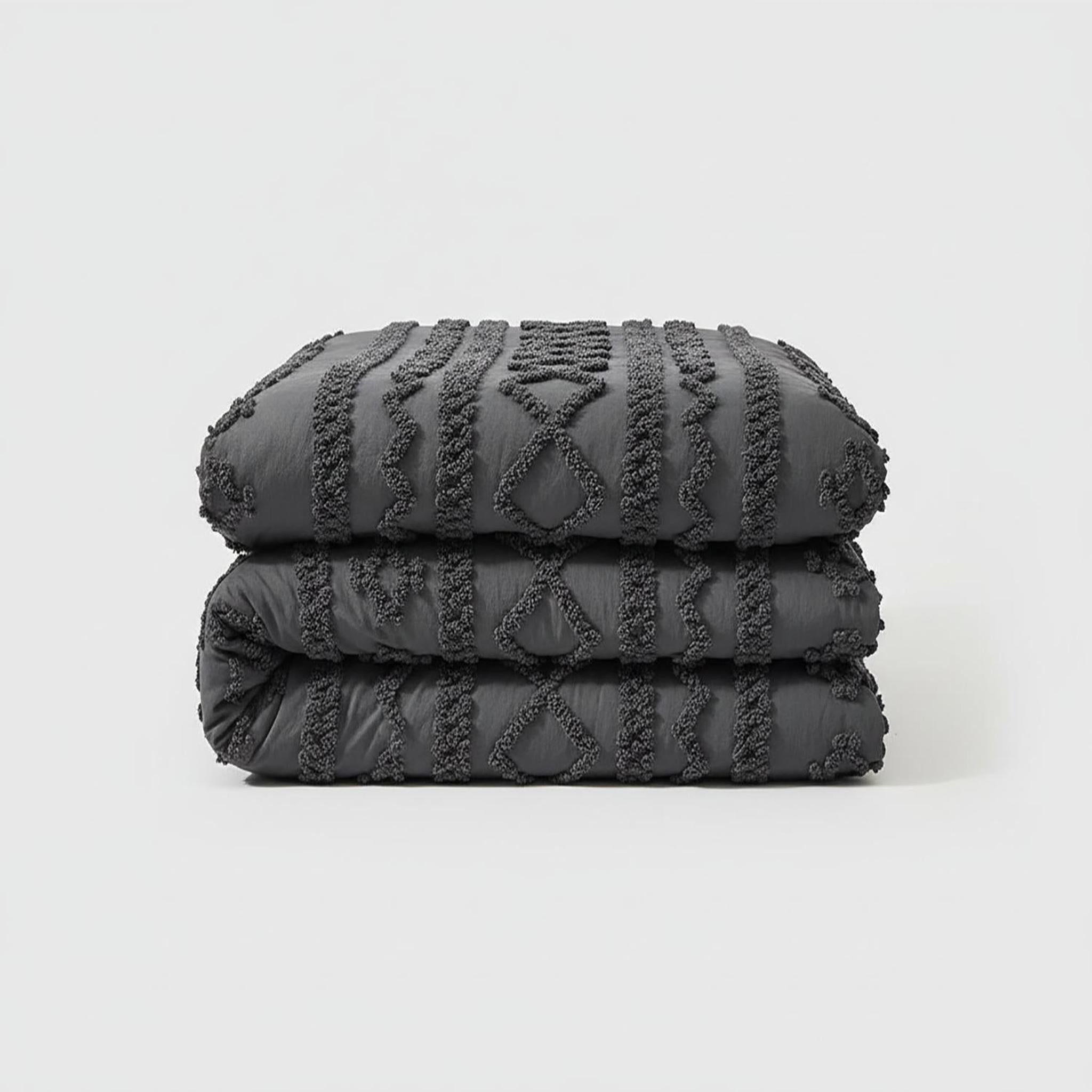 Folded dark gray queen size boho comforter set with soft tufted cotton polyester texture.