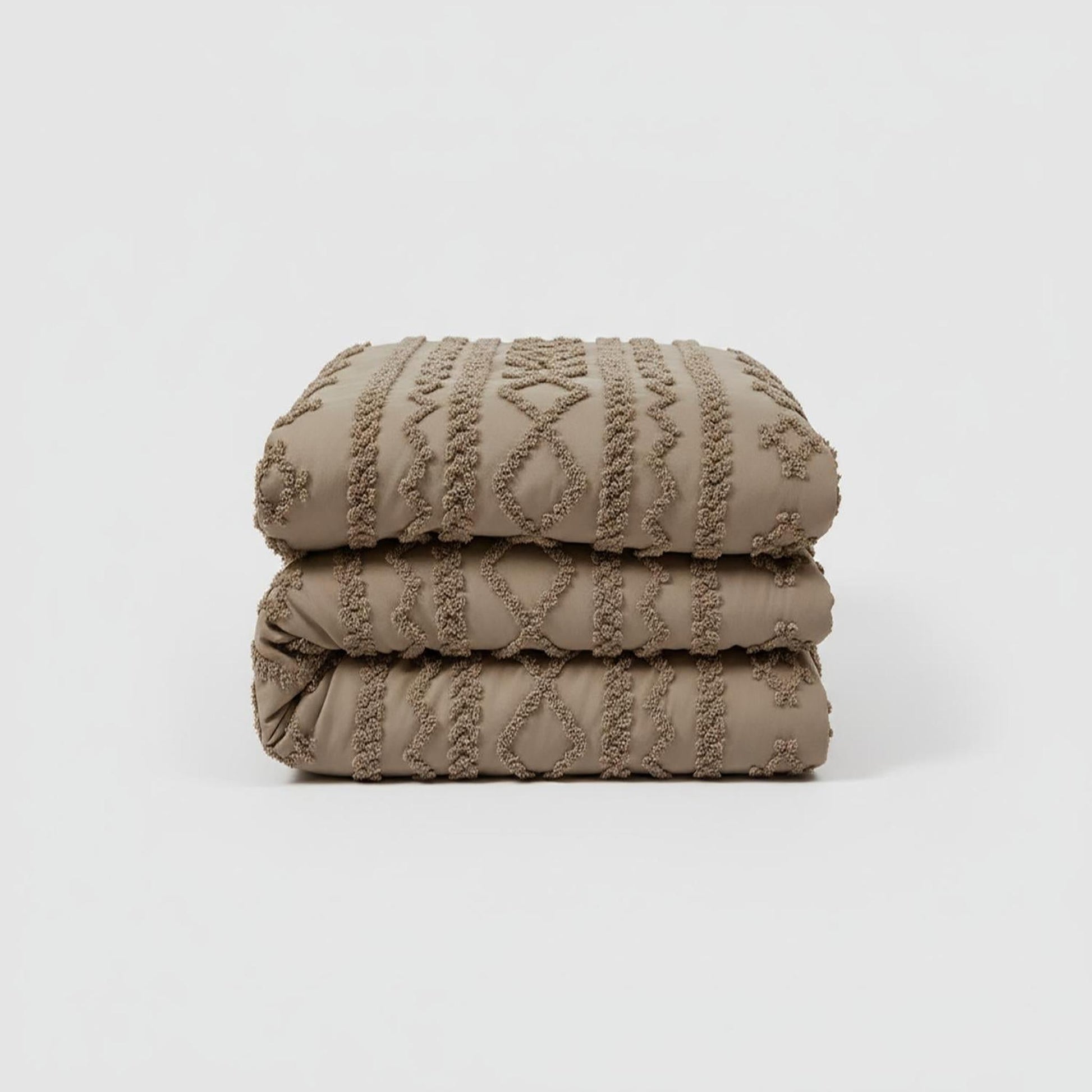 Queen size Boho Comforter Set in soft tufted taupe cotton polyester, folded.