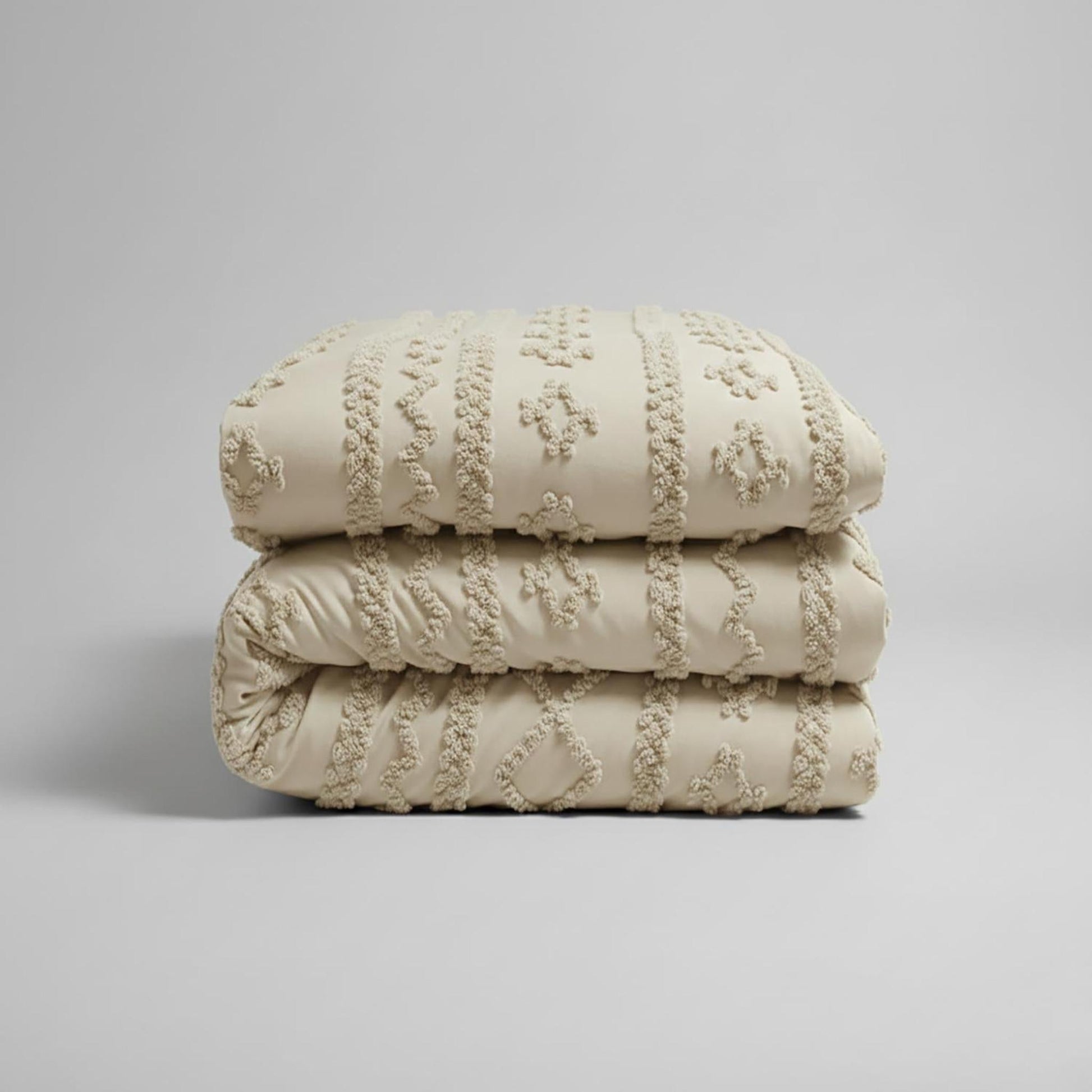 Folded queen size boho comforter set in soft tufted beige cotton polyester with jacquard texture.