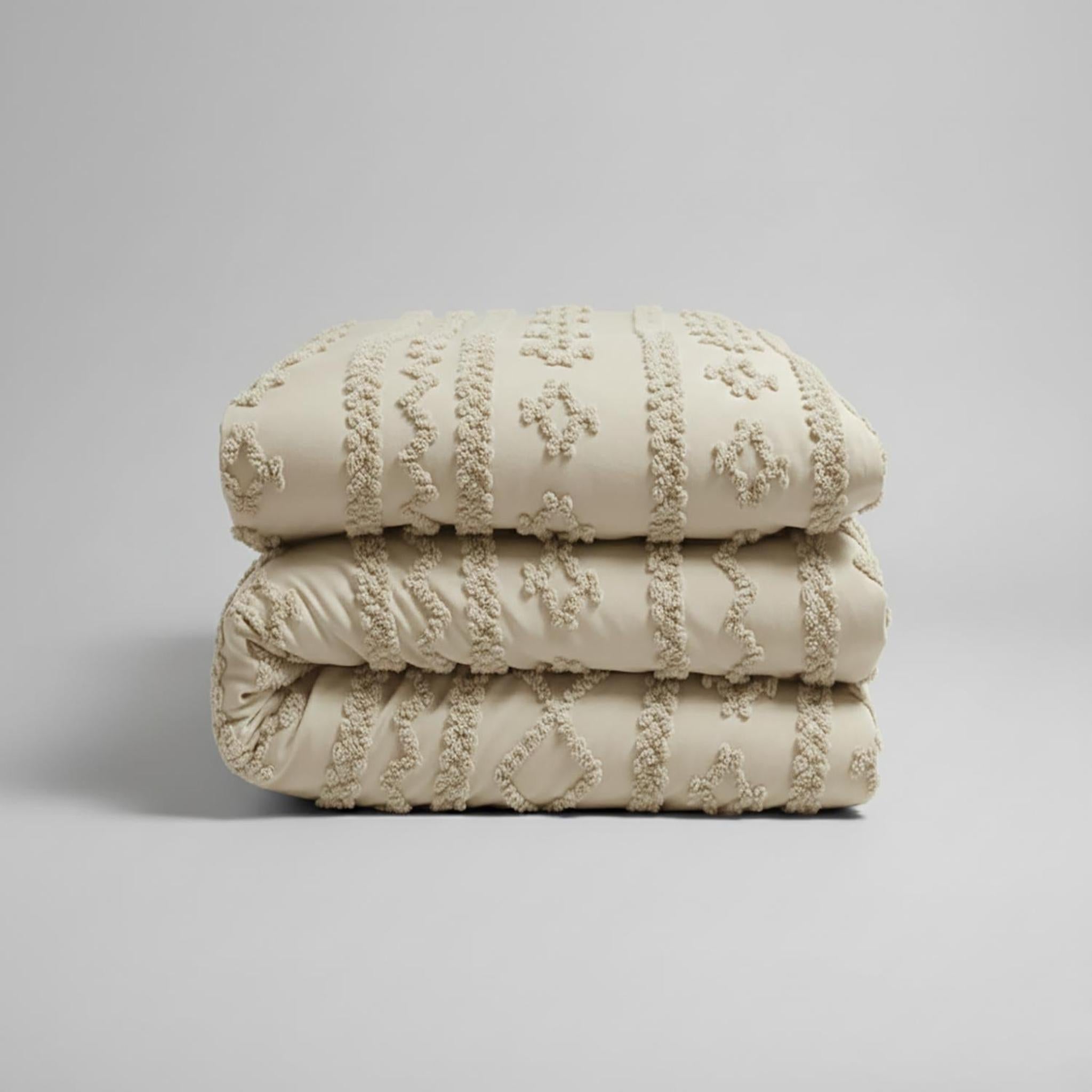 Folded queen size boho comforter set in soft tufted beige cotton polyester with jacquard texture.