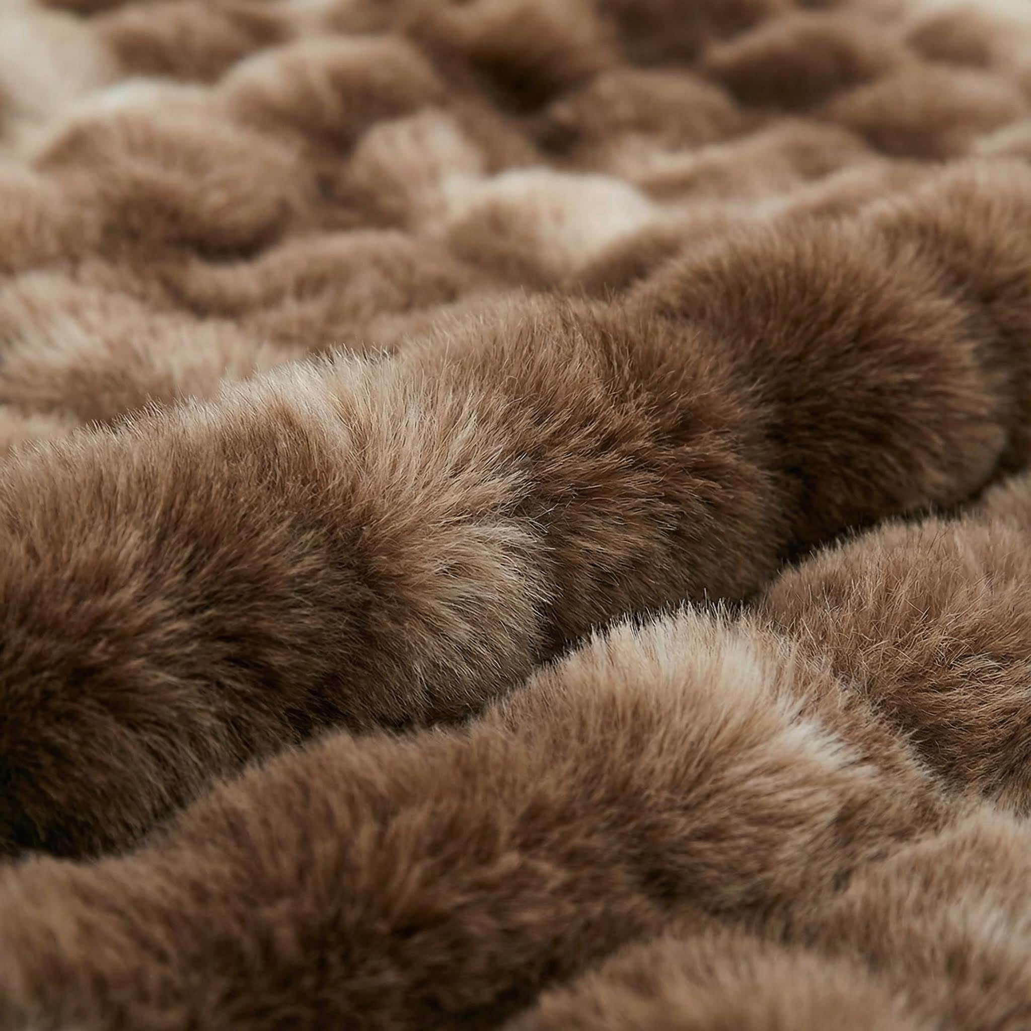 Close-up of a soft, brown bubble plush throw blanket made from polyester fiber.