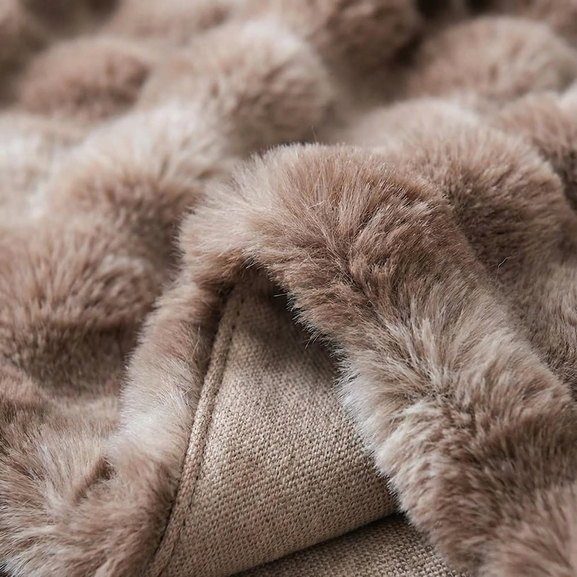 Close-up of a soft, light brown bubble plush throw blanket made from polyester fiber.
