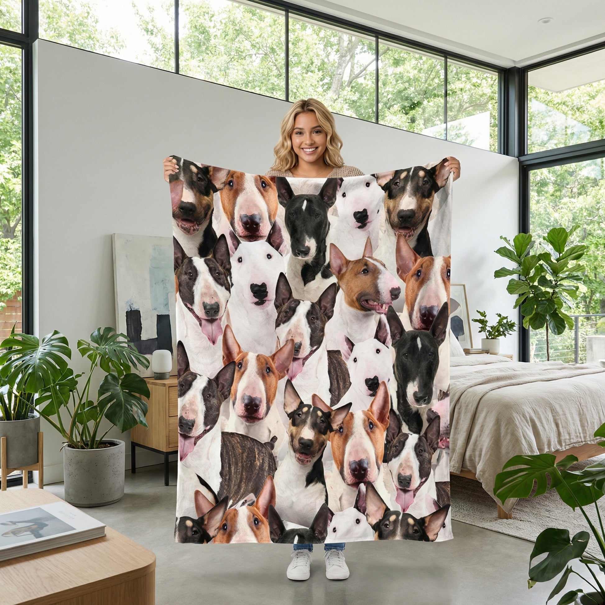 Smiling woman holding a soft Sherpa blanket with a vibrant 3D print of many Bull Terrier dogs.