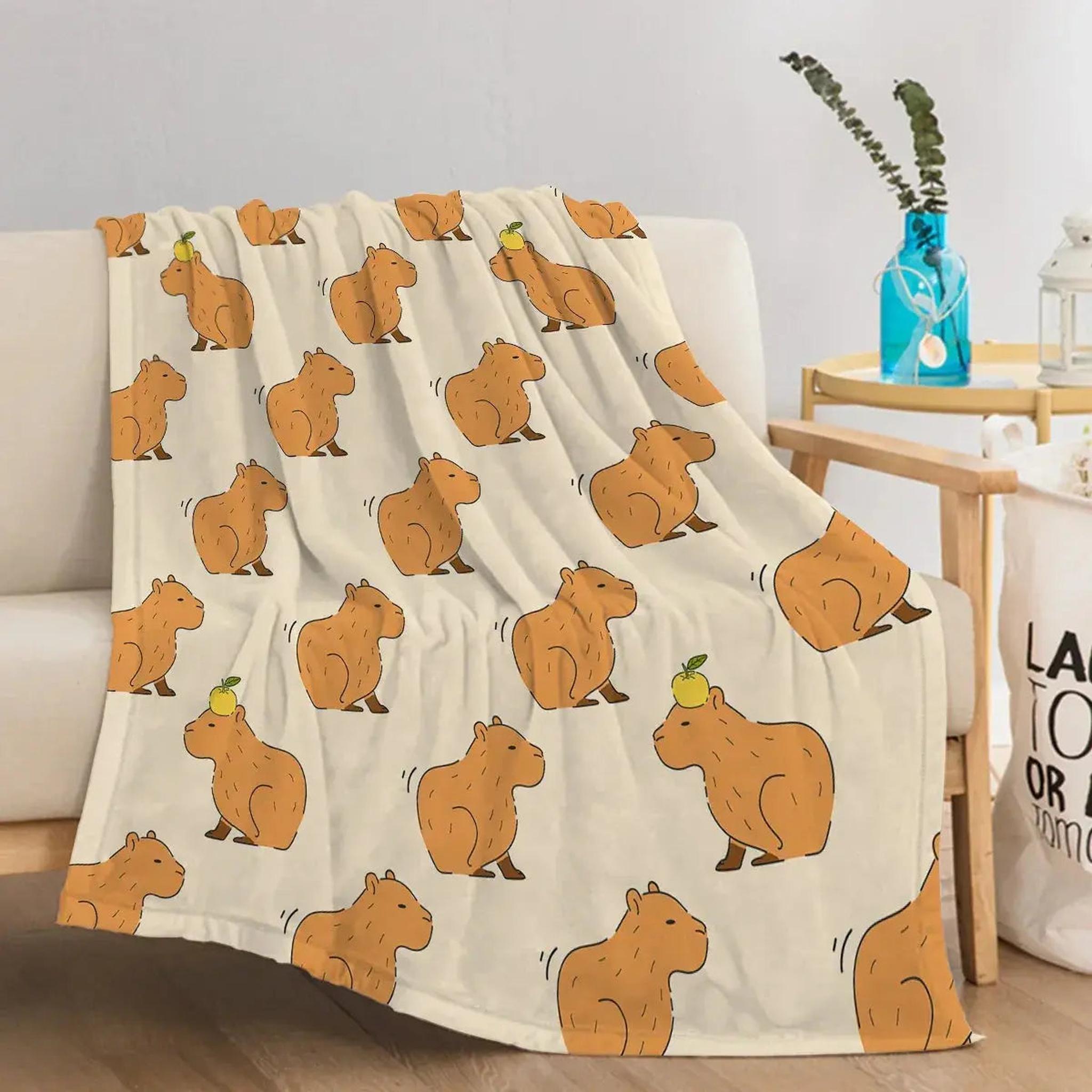 Soft flannel blanket with a playful pattern of brown capybaras on a light background.