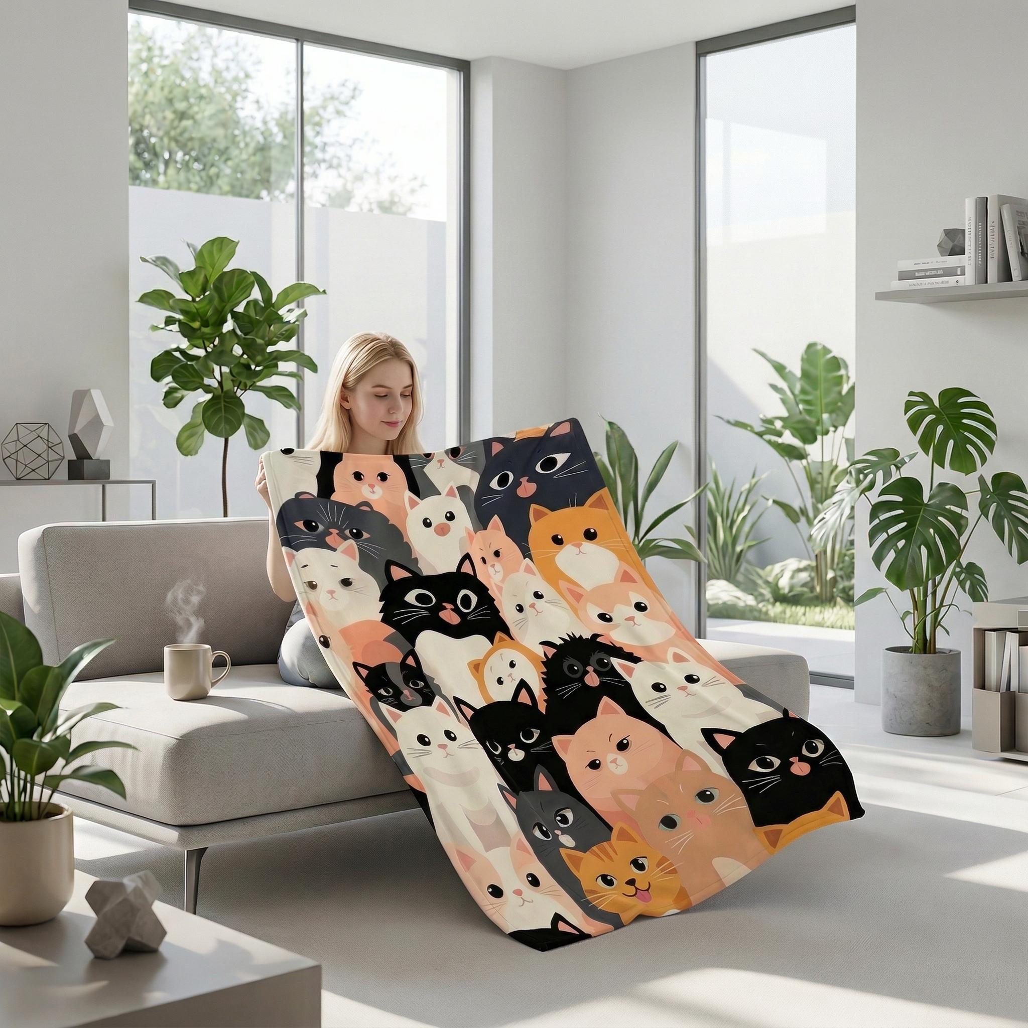 Blonde woman on a sofa holding a soft flannel blanket with a cute, colorful cartoon cat pattern.
