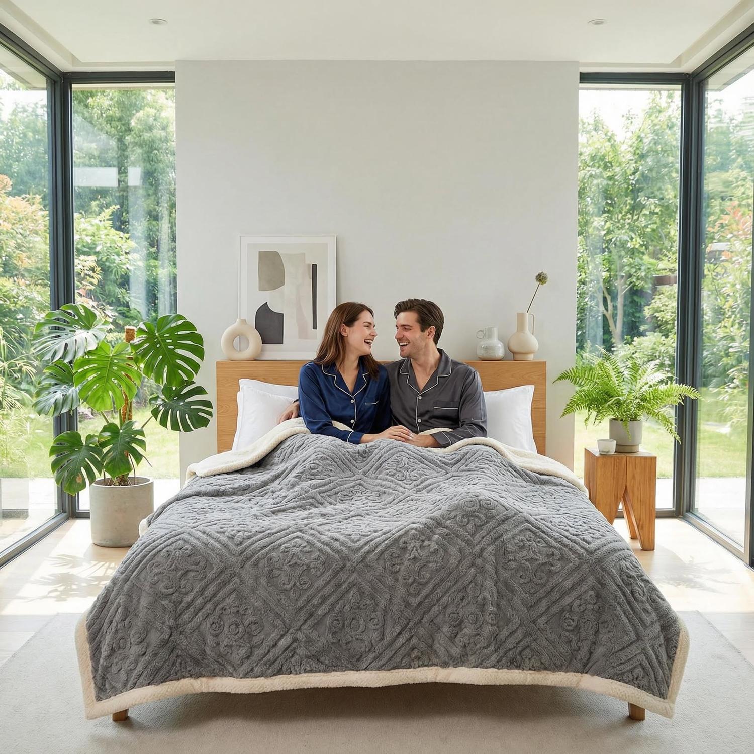 Cozy couple under a gray carved velvet bed blanket with a cream sherpa reverse.