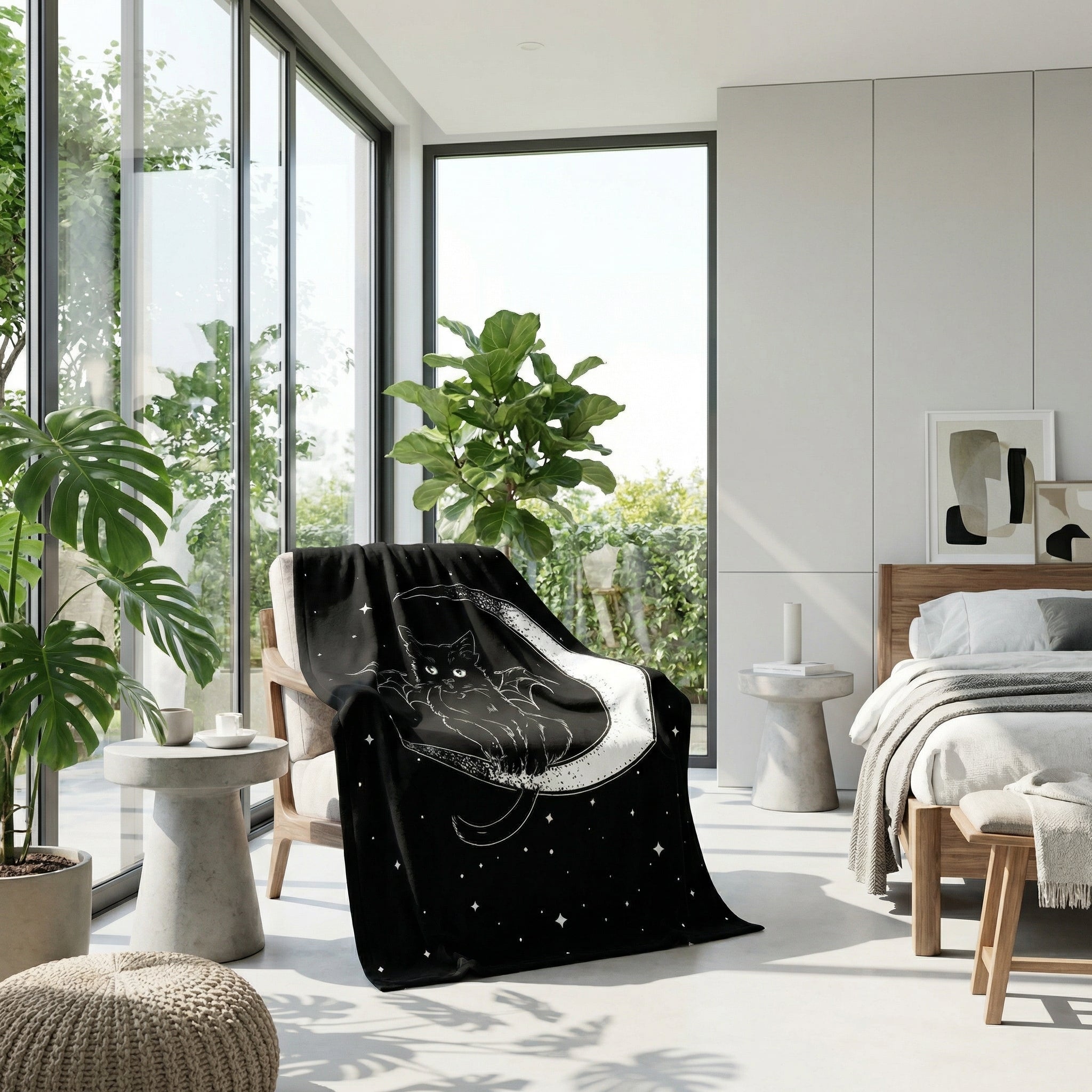 Black flannel throw blanket with a white cat and moon 3D print draped over a chair in a modern room.