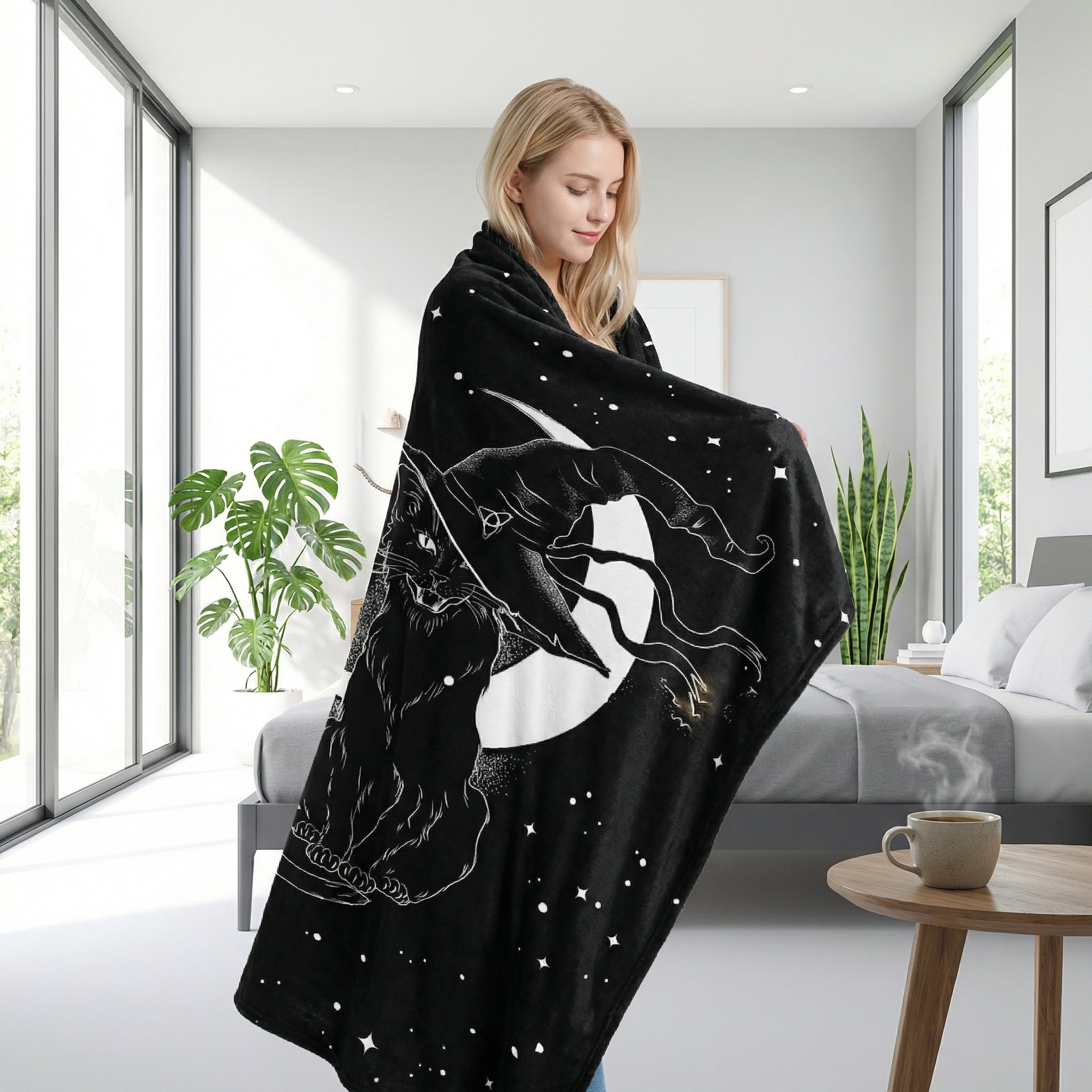 Black flannel throw blanket with white cat and moon 3D print, draped over a woman in a modern bedroom.