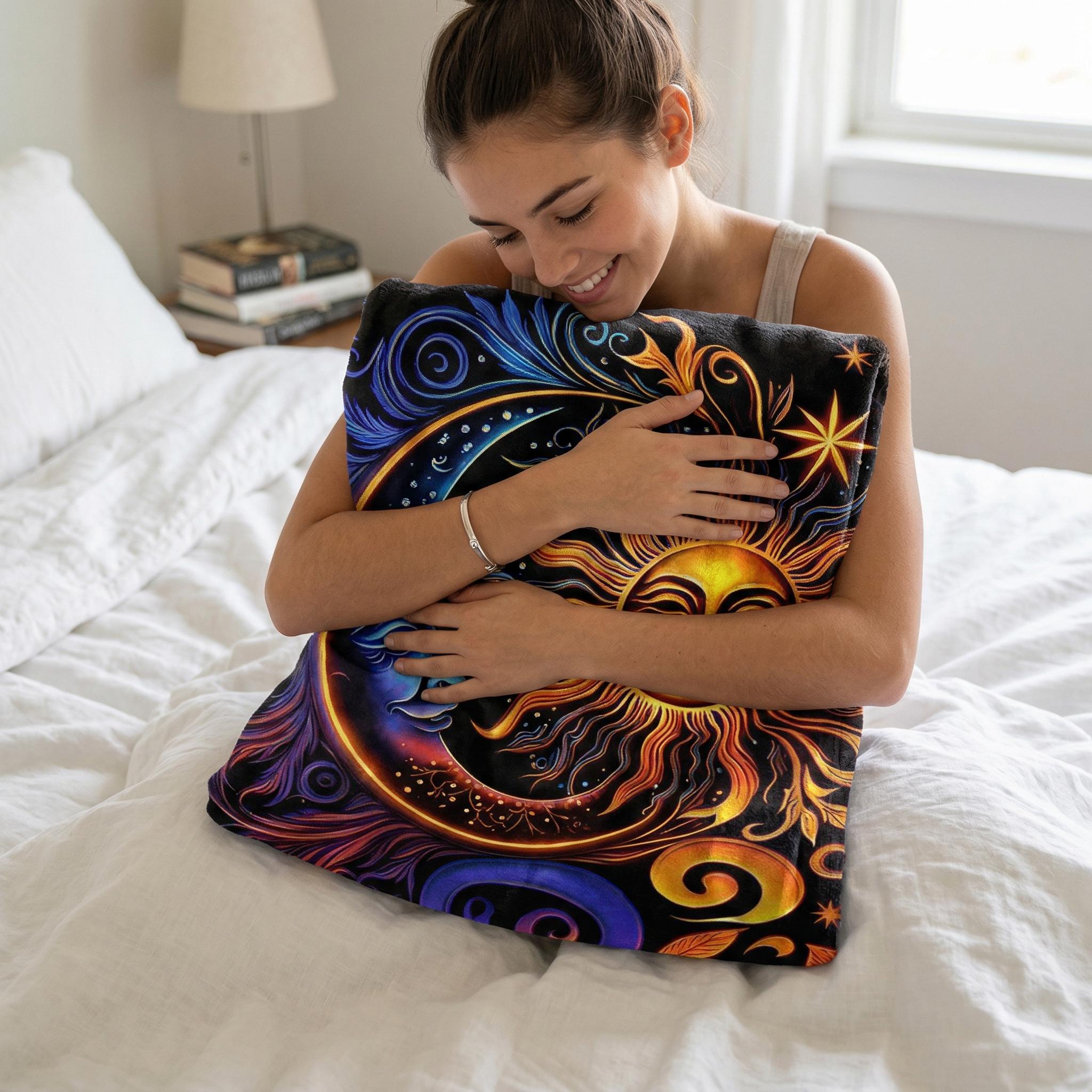 Smiling woman hugging a soft, black Celestial Dreams throw blanket with a vibrant sun and moon design.