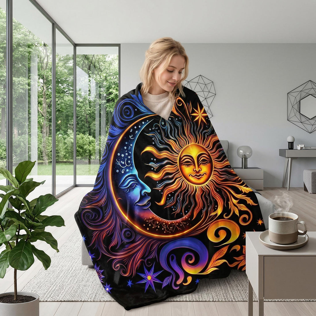 Woman wrapped in a black Celestial Dreams throw blanket with a vibrant sun and moon design.