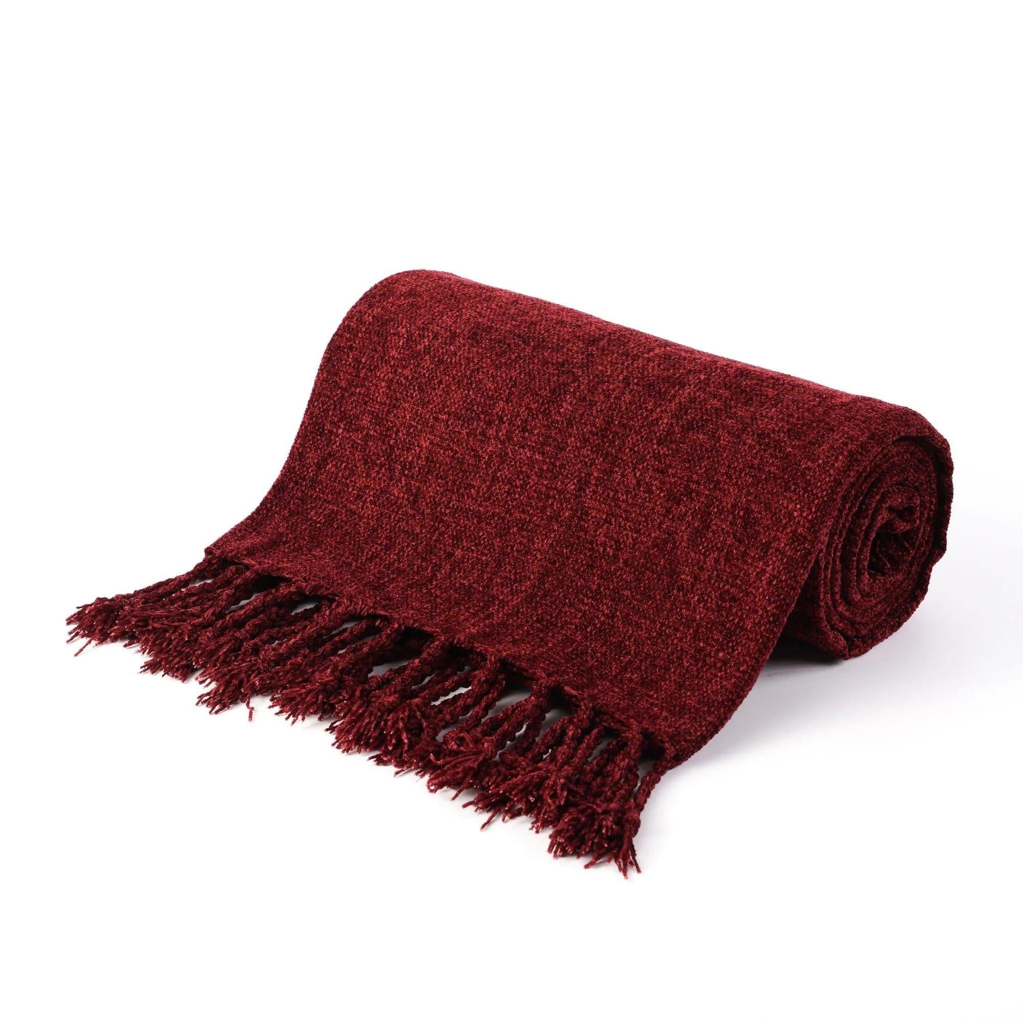 Rolled red chenille throw blanket with fringe tassels, made from soft, breathable polyester.