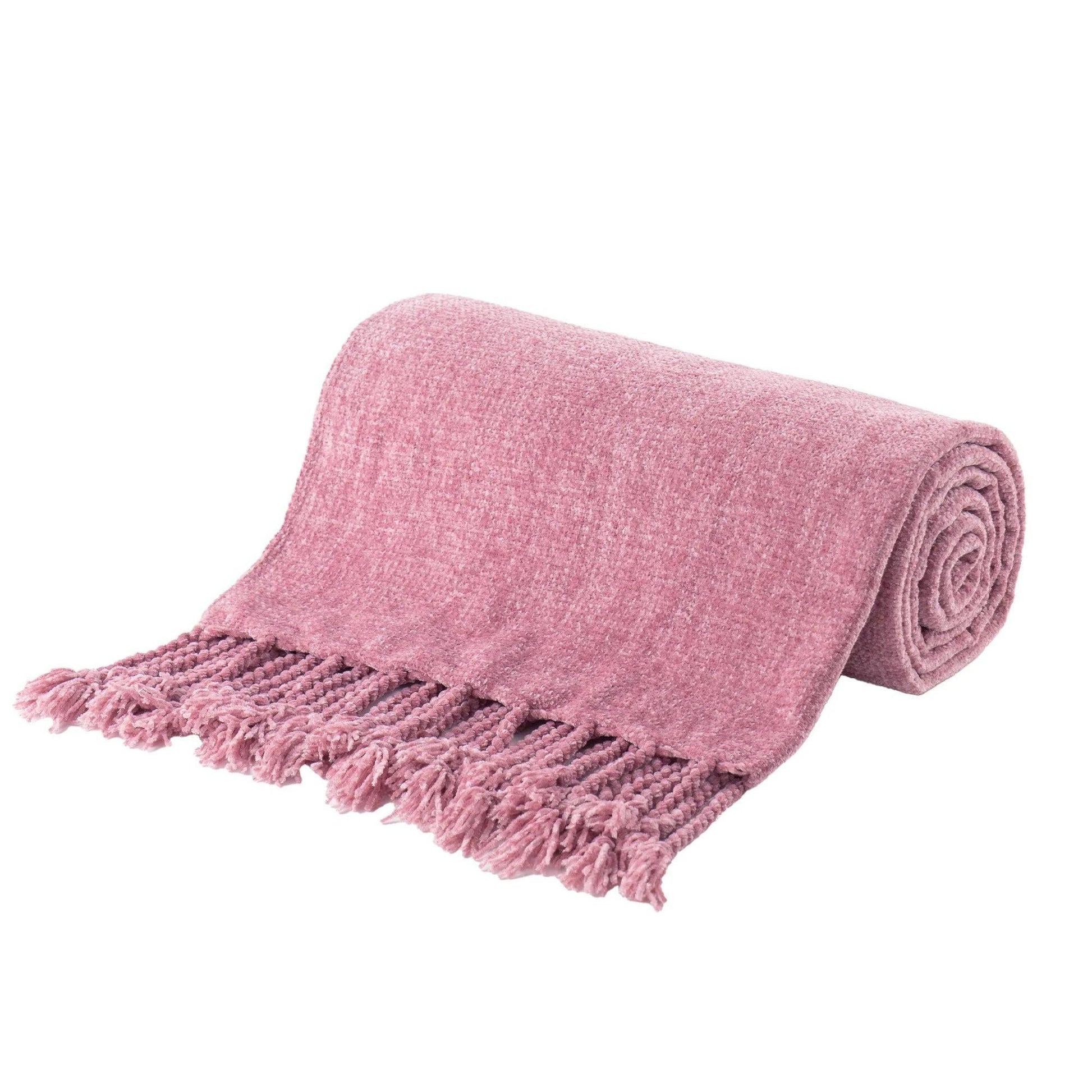 Pink chenille throw blanket with fringe tassels, rolled up on a white background.