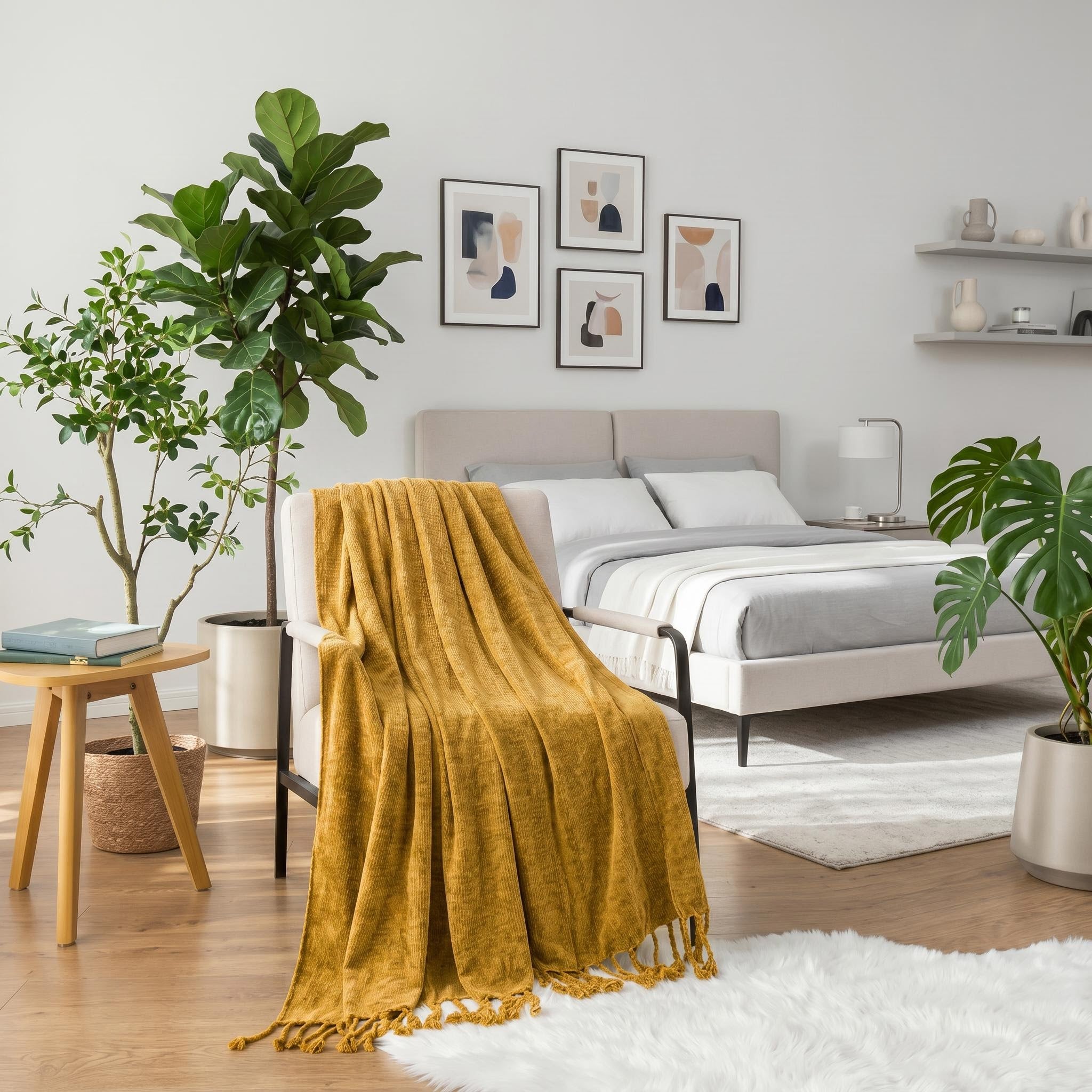 Mustard yellow chenille throw blanket with fringe tassels draped over a cream armchair in a bright bedroom.