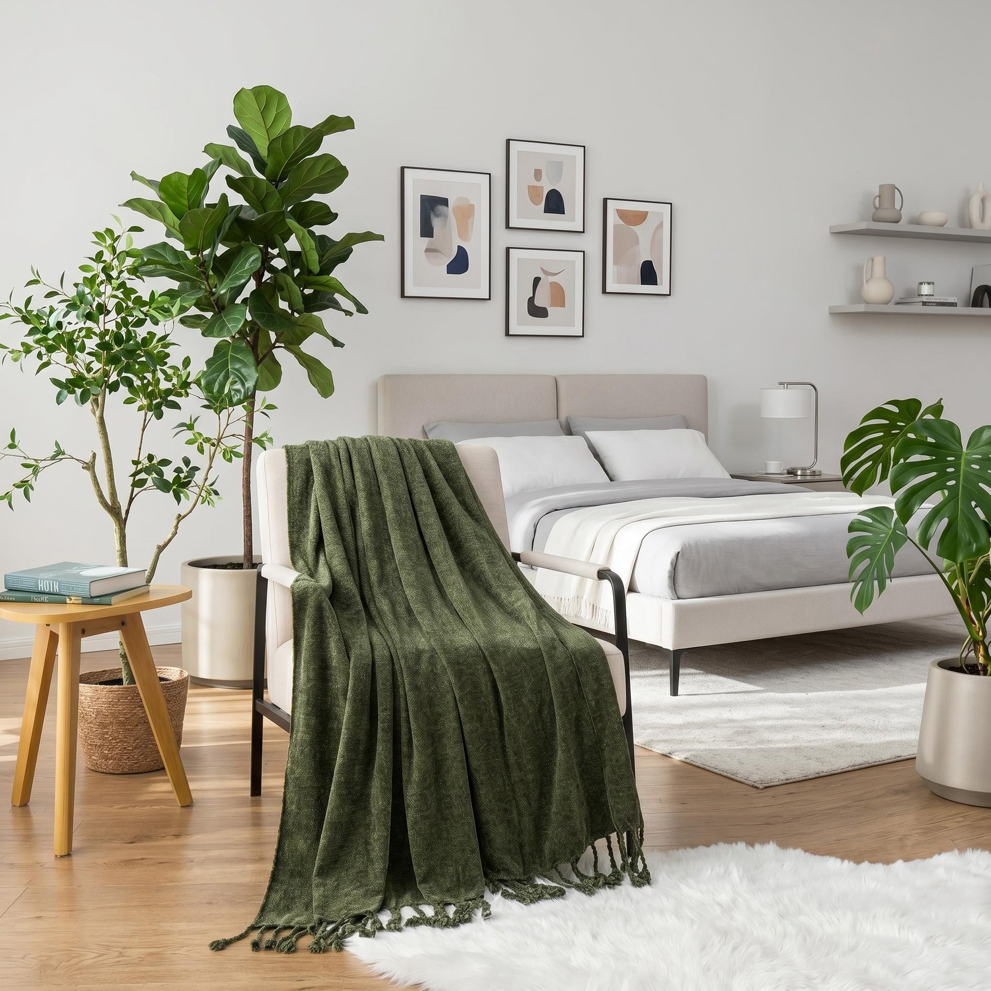 Green chenille throw blanket with fringe tassels draped over a cream armchair in a bright bedroom.
