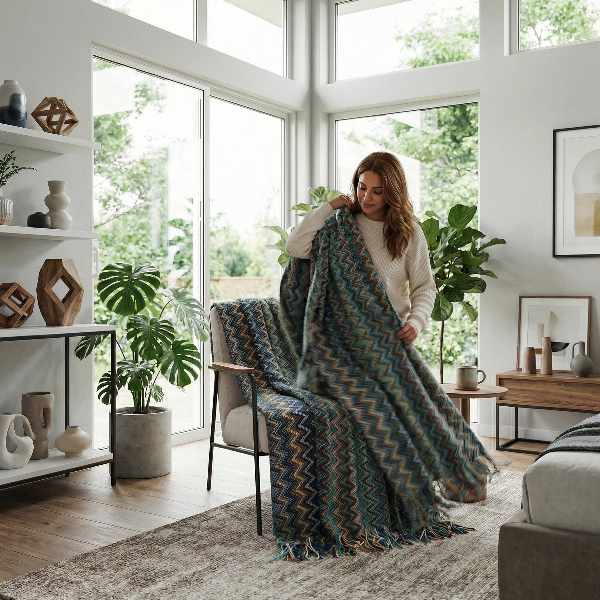 Woman holding a chic hand-knitted acrylic blanket with a blue, green, and beige zigzag pattern and tassels.