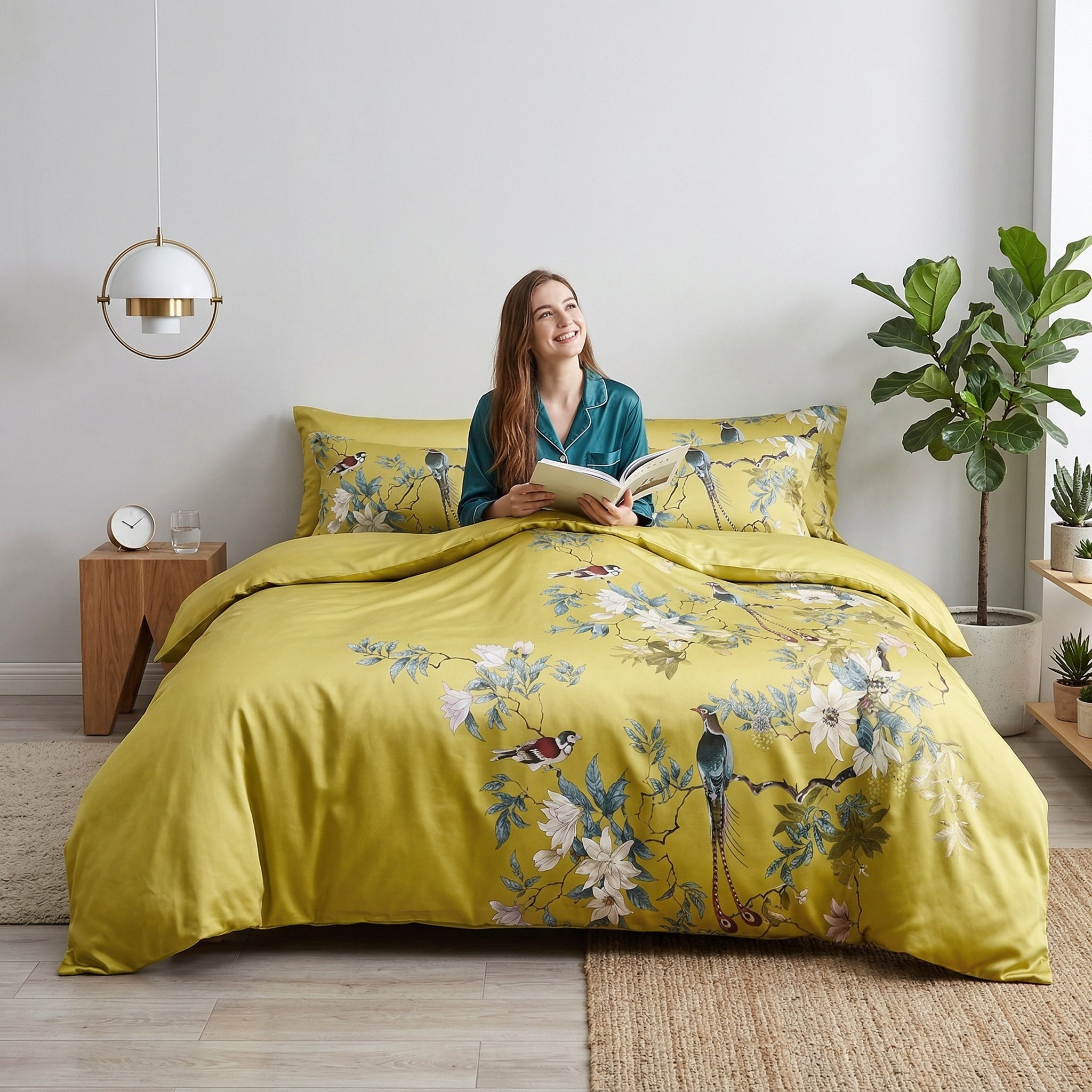 King size Chinoiserie Birds and Flowers Duvet Cover Set in yellow Egyptian cotton with a woman reading.