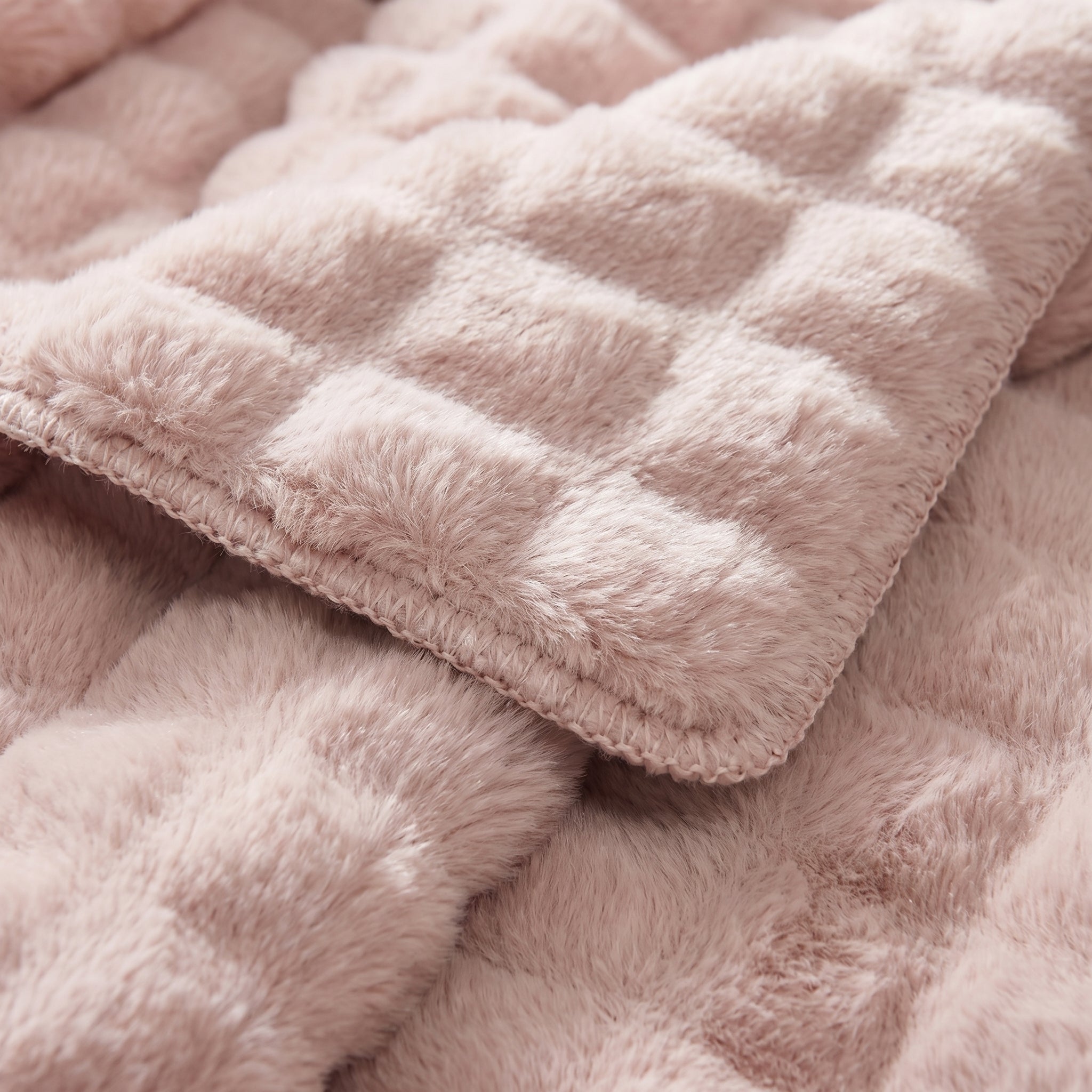 Close-up of a soft, pink CloudLoom Plush Throw Blanket with a quilted texture.