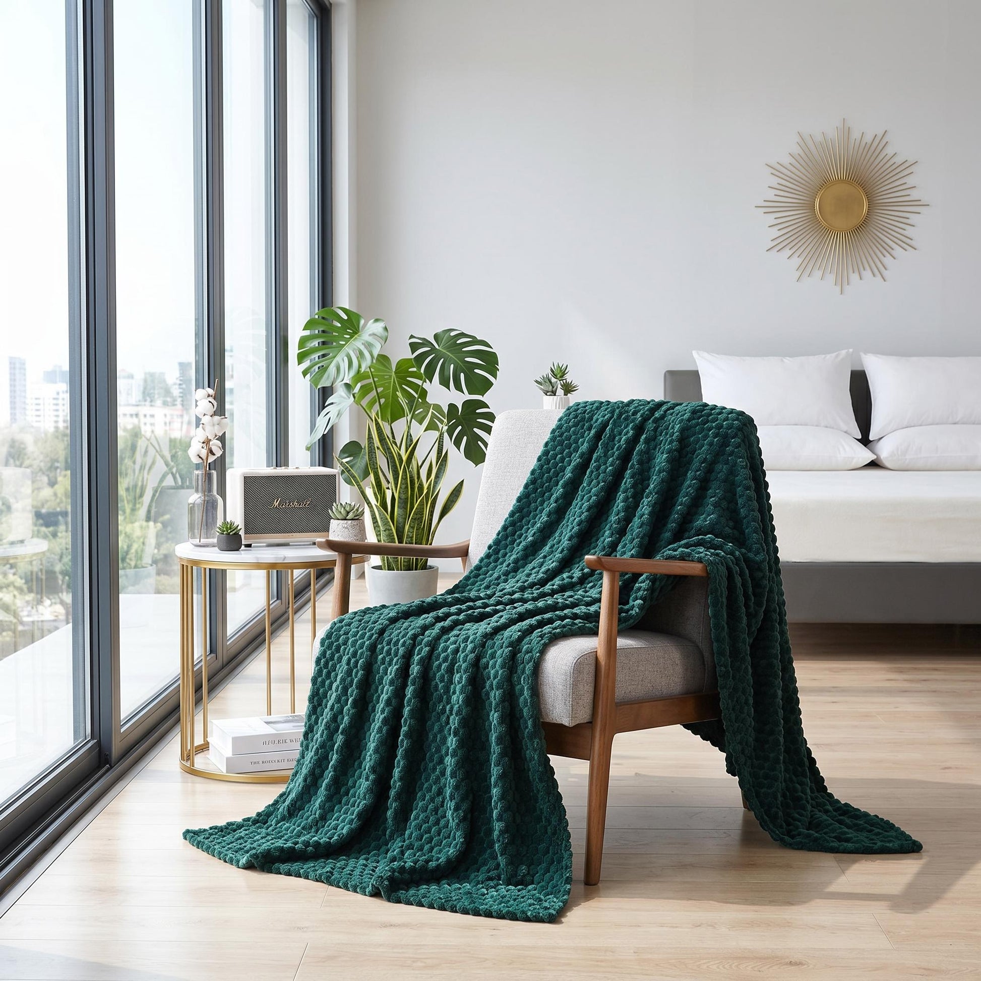 Emerald green jacquard fleece blanket draped over a gray armchair in a bright, modern room.