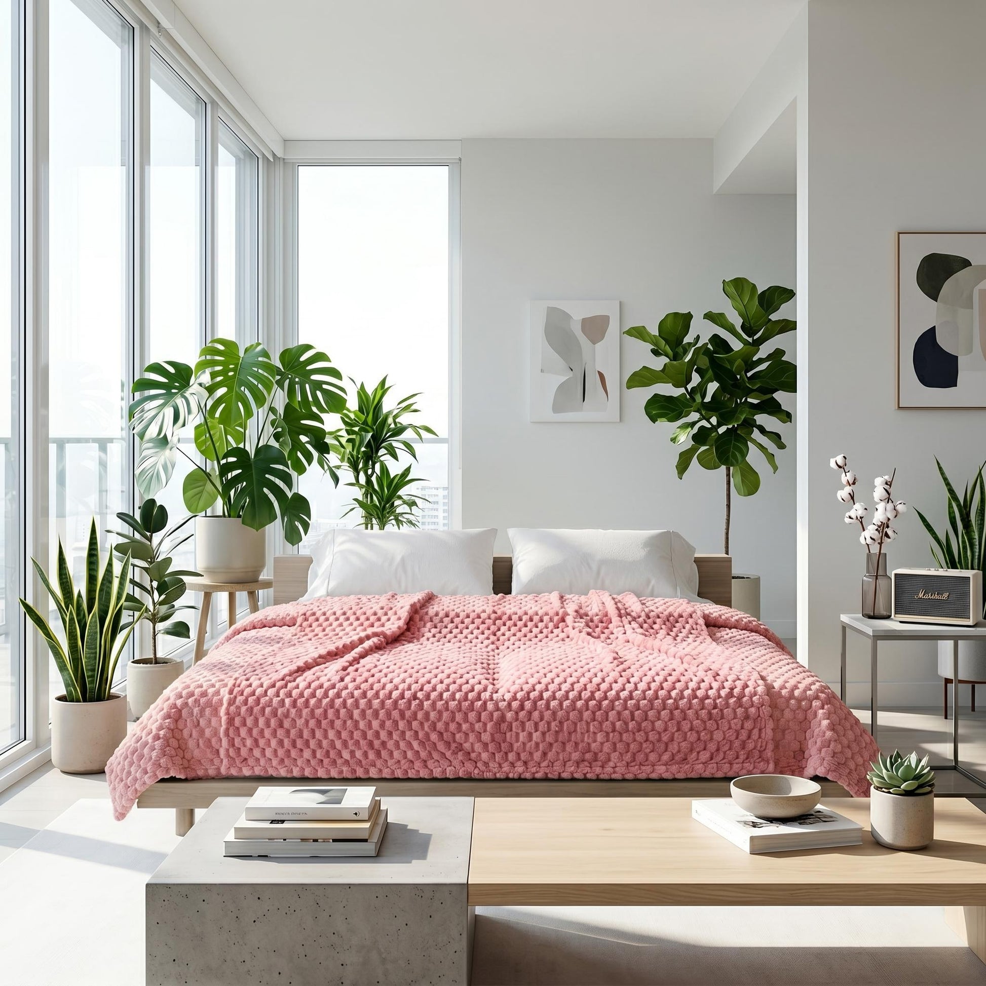 Pink Clouds Jacquard Fleece Blanket on a bed in a bright, modern bedroom with plants.