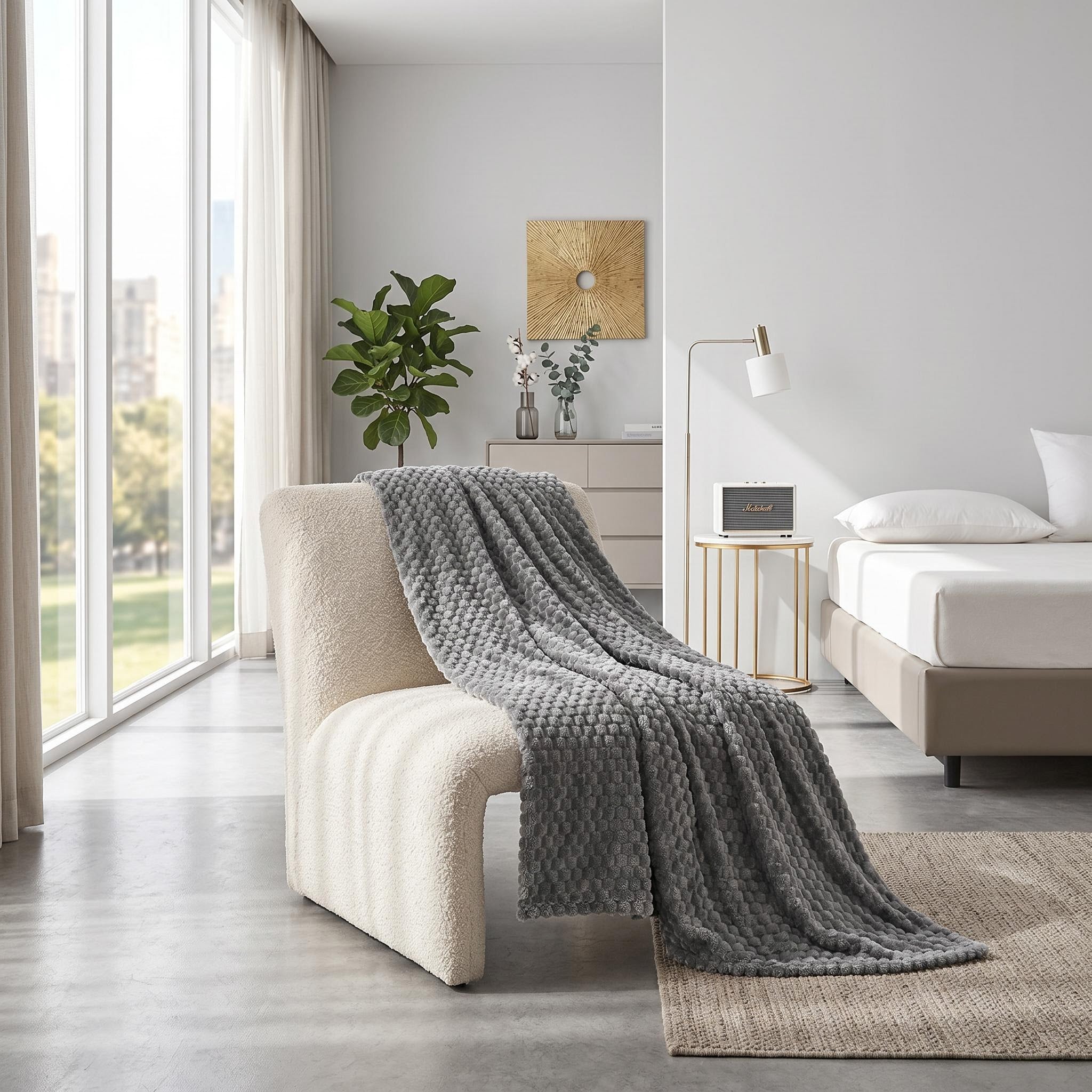 Gray Clouds Jacquard Fleece Blanket draped over a cream chair in a bright, modern room.