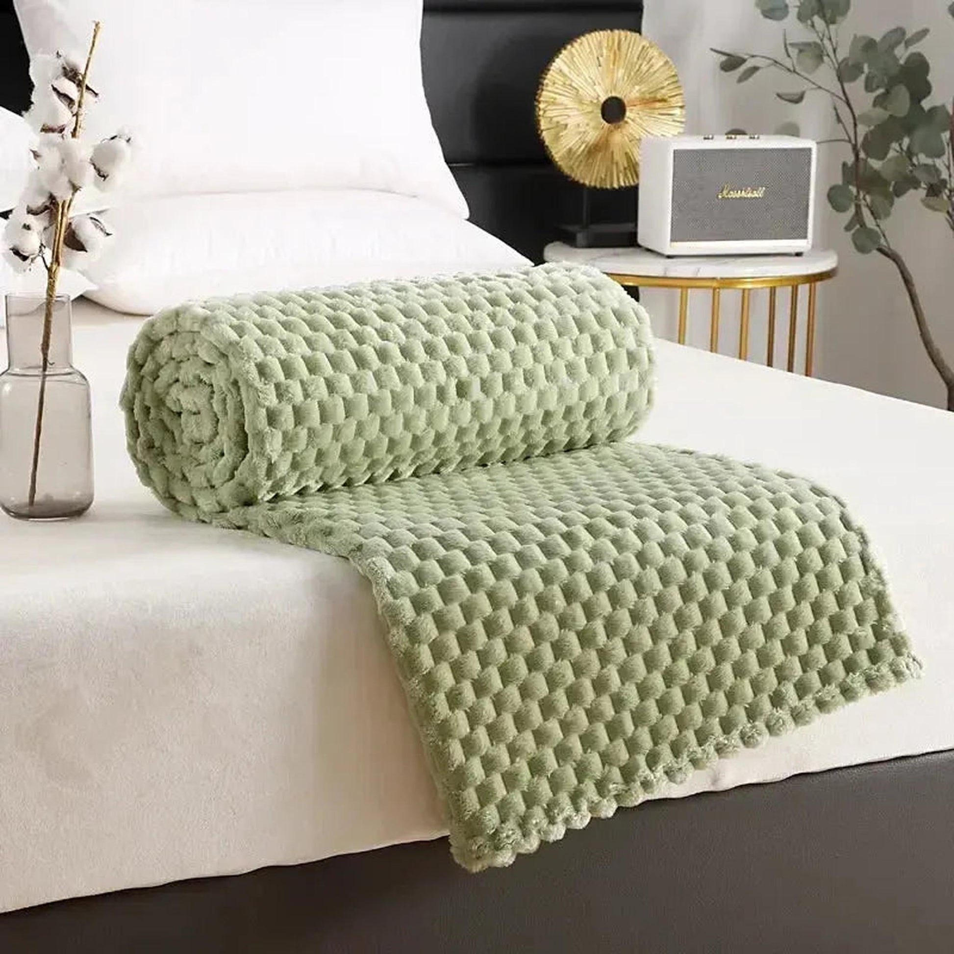 Soft sage green Clouds Jacquard Fleece Blanket with a 3D cloud pattern, rolled on a white bed.