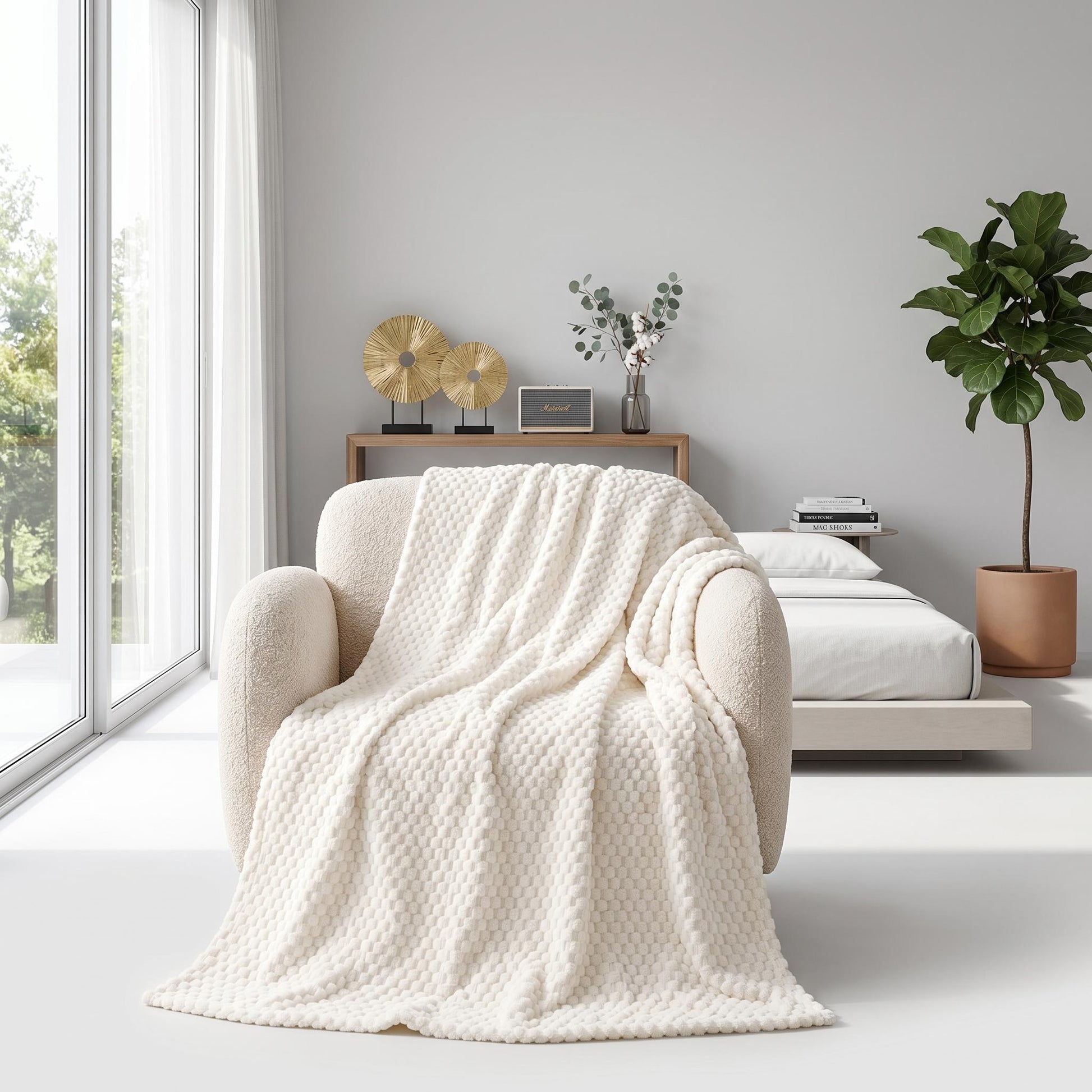Cream silky flannel fleece blanket with 3D cloud jacquard texture draped over a cozy armchair.
