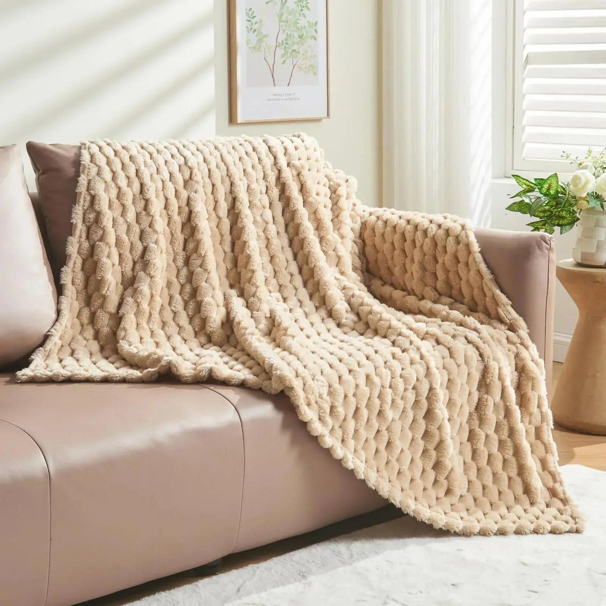 Beige Clouds Jacquard Fleece Blanket draped over a sofa, featuring a soft 3D cloud pattern.