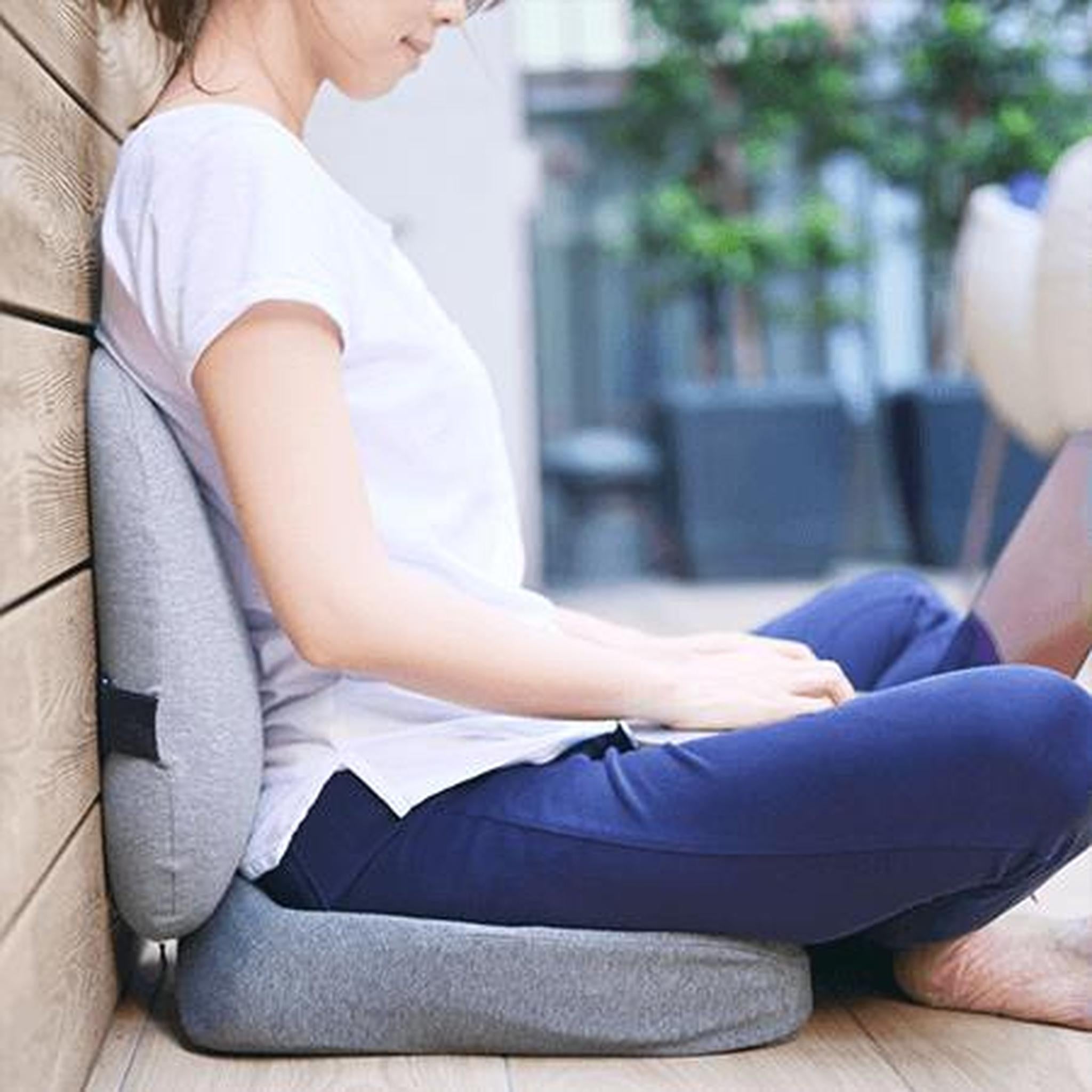 Woman sitting on a gray ergonomic foam seat and back cushion set, promoting balanced posture.