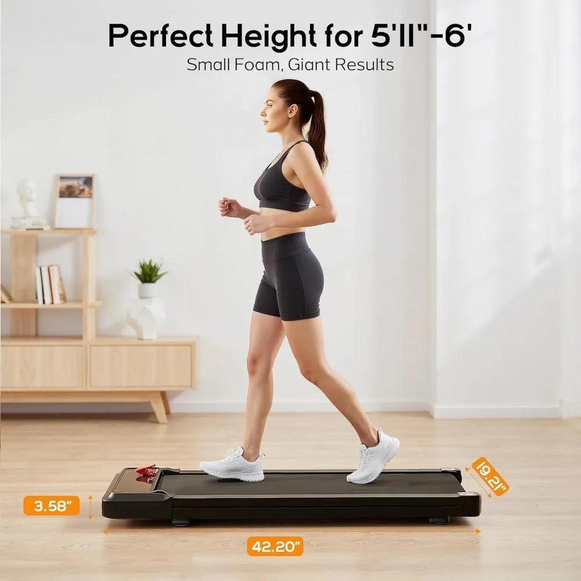 Woman walking on a compact black under-desk treadmill with dimensions shown.