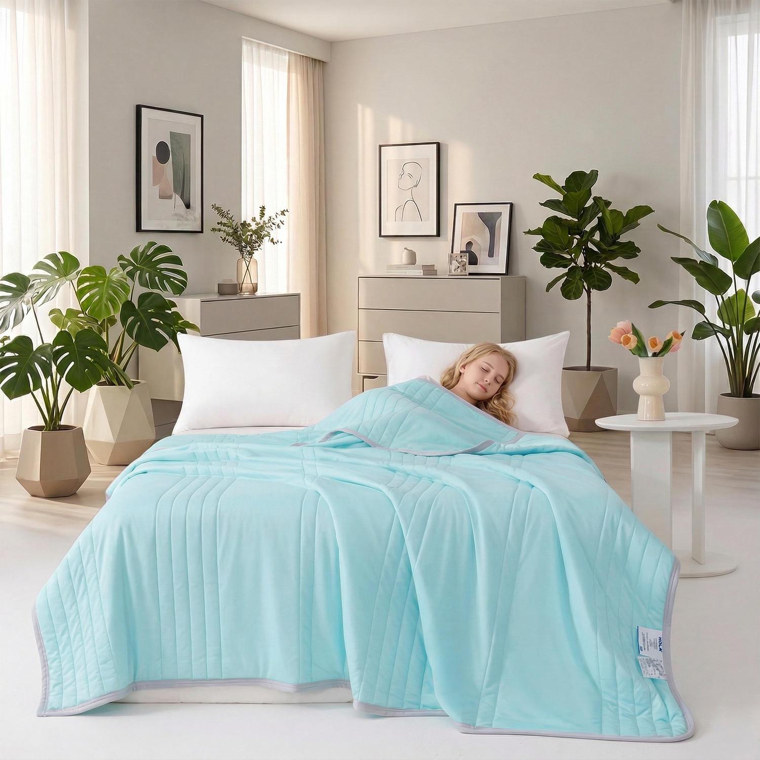 Light blue Cool Silk Summer Quilt with a soft, quilted texture on a bed with a sleeping person.