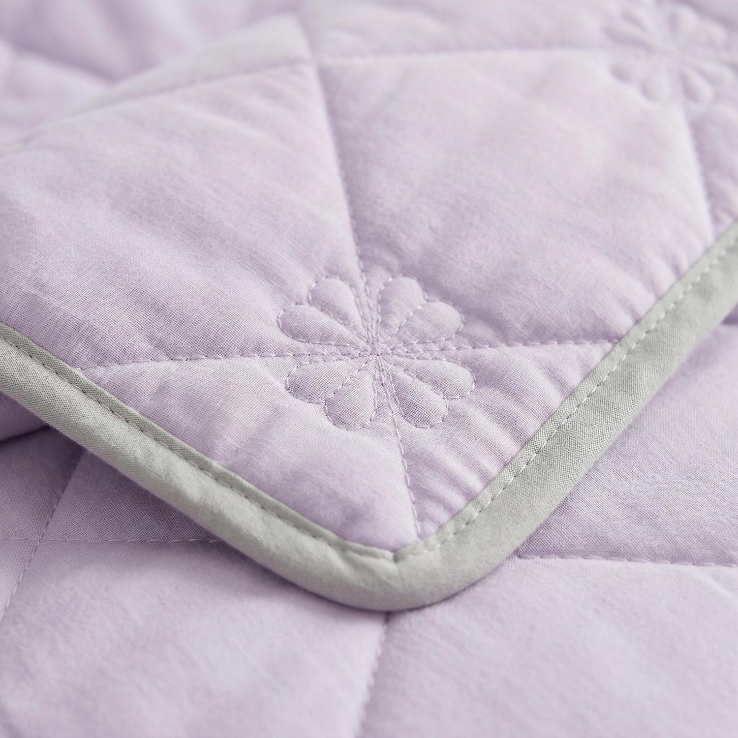 Light purple cooling blanket with quilted diamond pattern and a subtle floral design, edged in light gray.