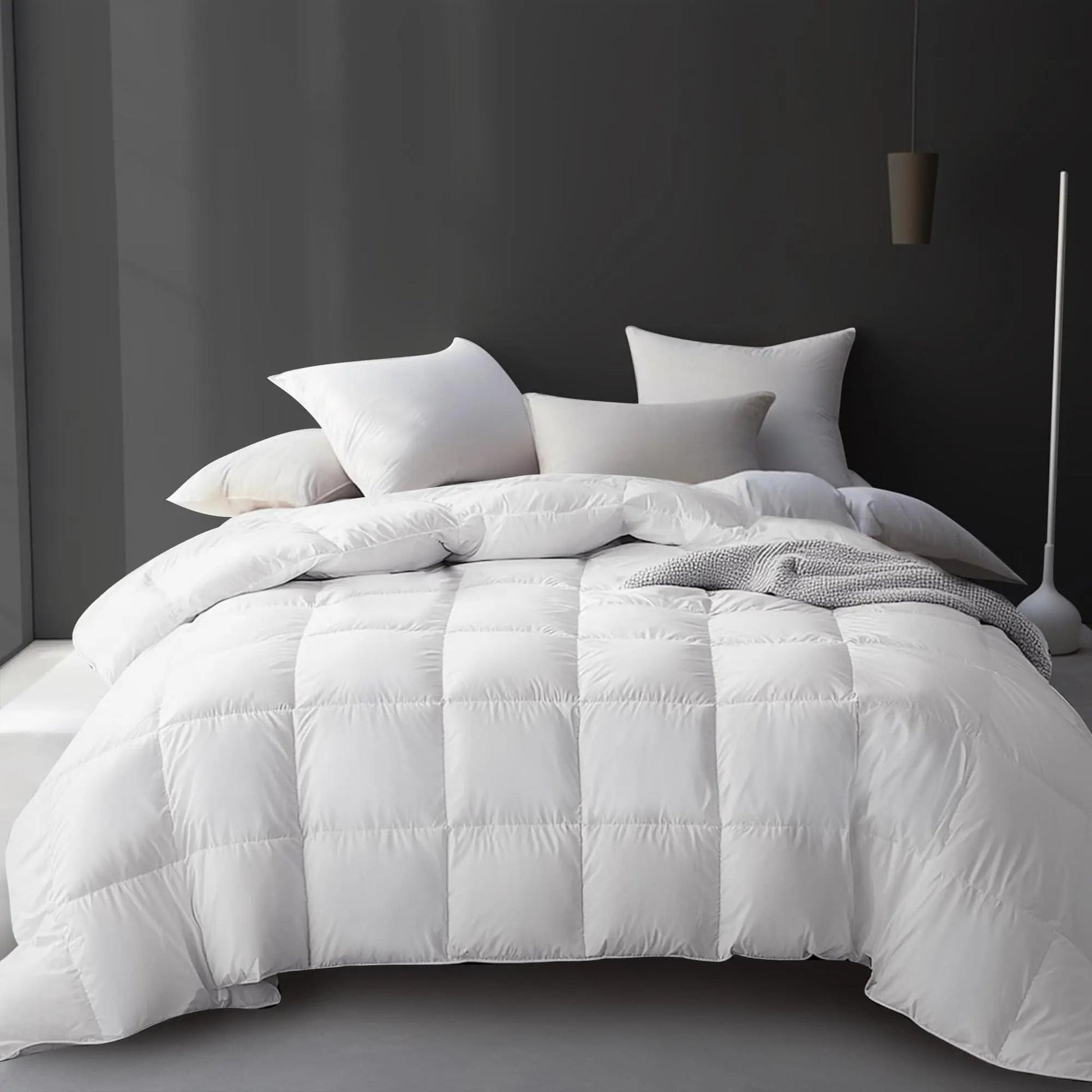 White goose down cooling comforter on a bed with pillows, featuring a quilted design.