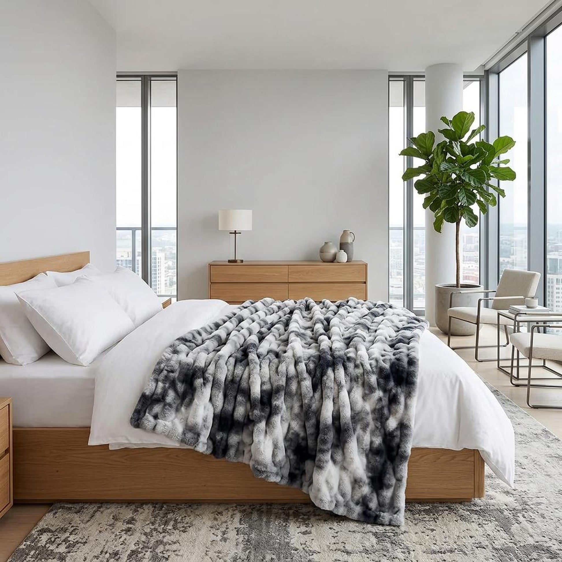 Plush gray and white faux rabbit fleece throw blanket draped on a modern bed.
