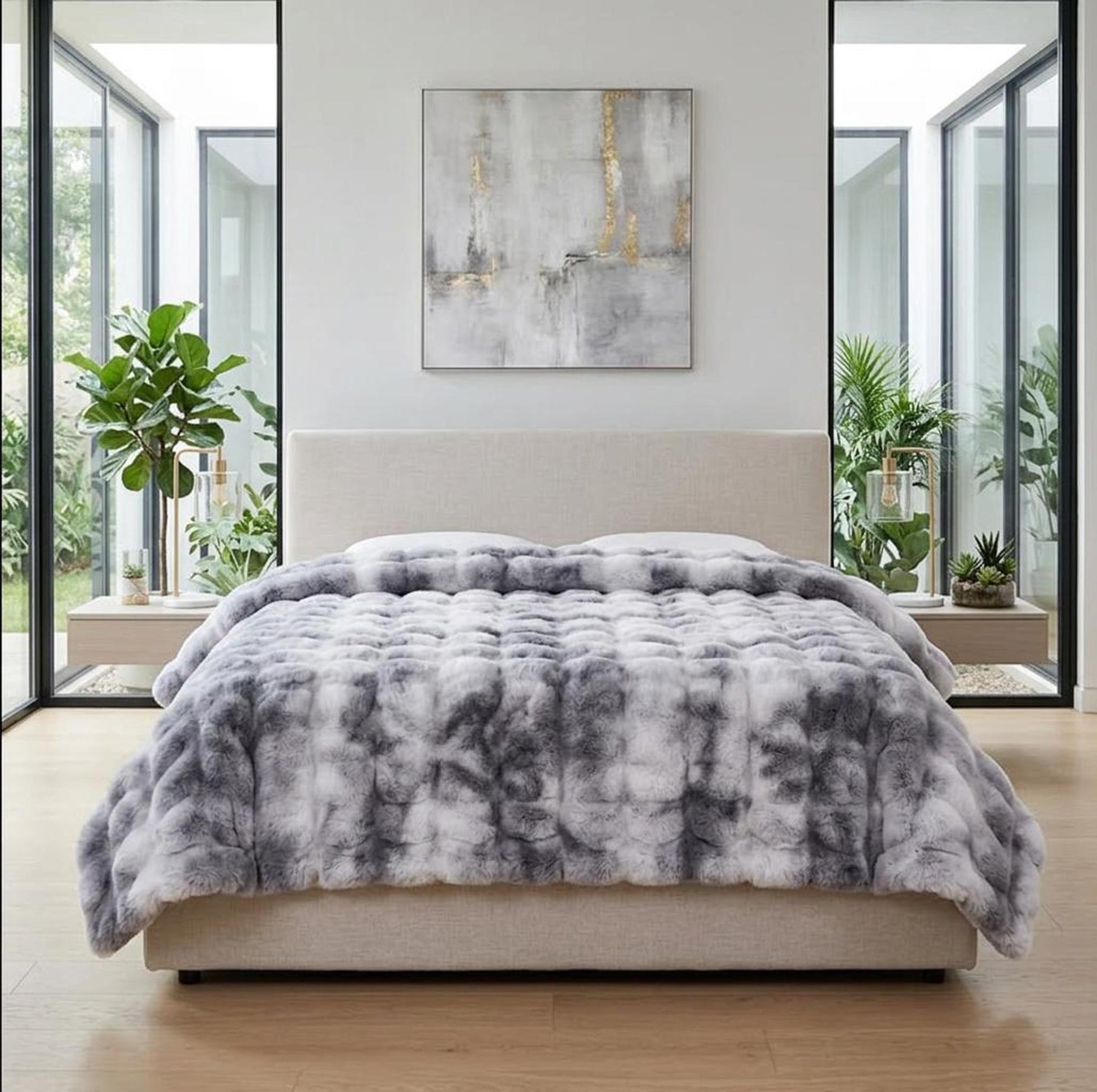 Plush gray and white tie-dye faux rabbit fleece throw blanket draped on a bed.