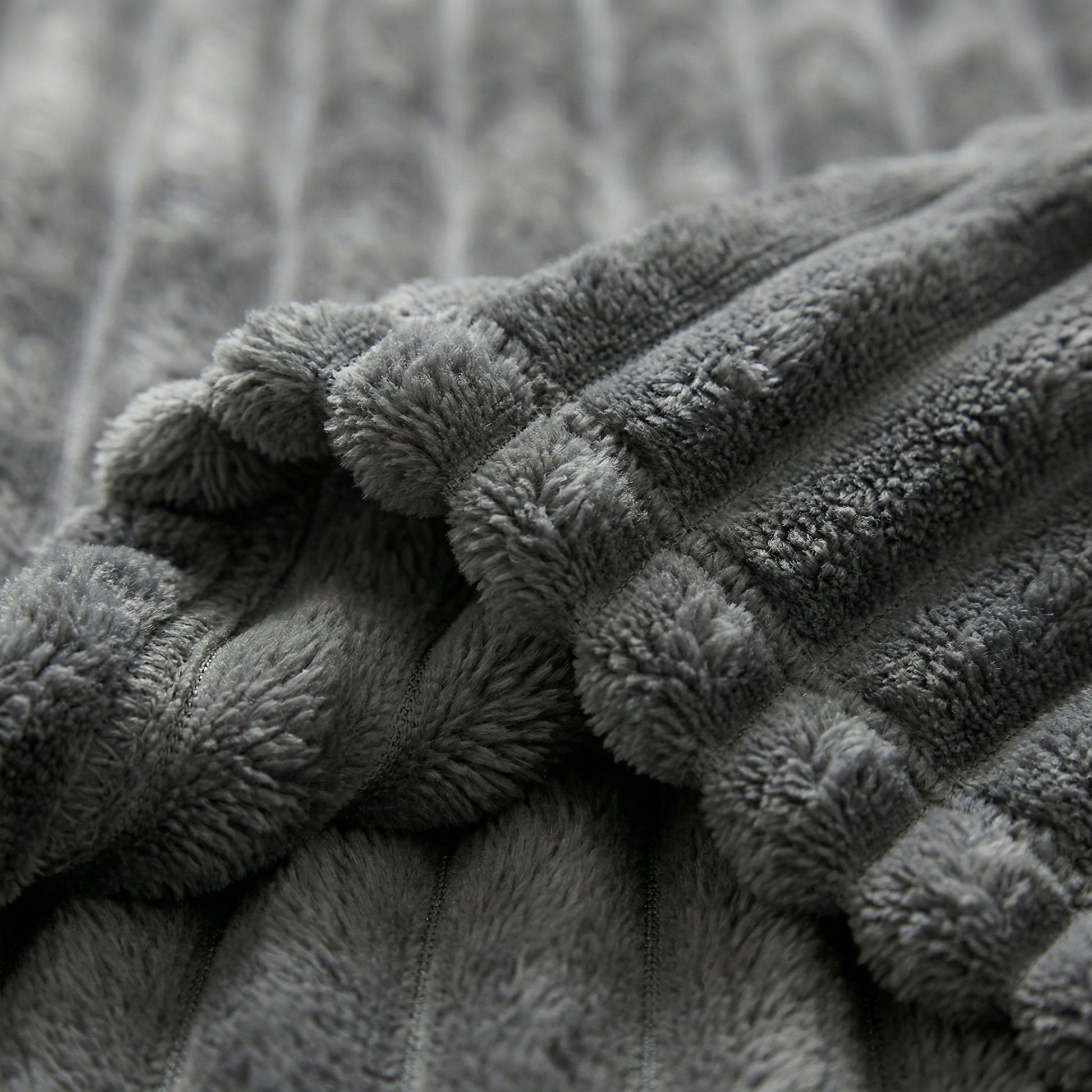 Close-up of a folded CozySoft Double-Sided Blanket in soft gray plush polyester with ribbed texture.